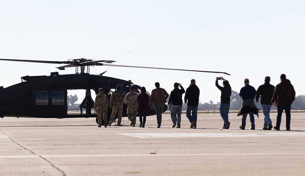 Civilians walk to helicopter.