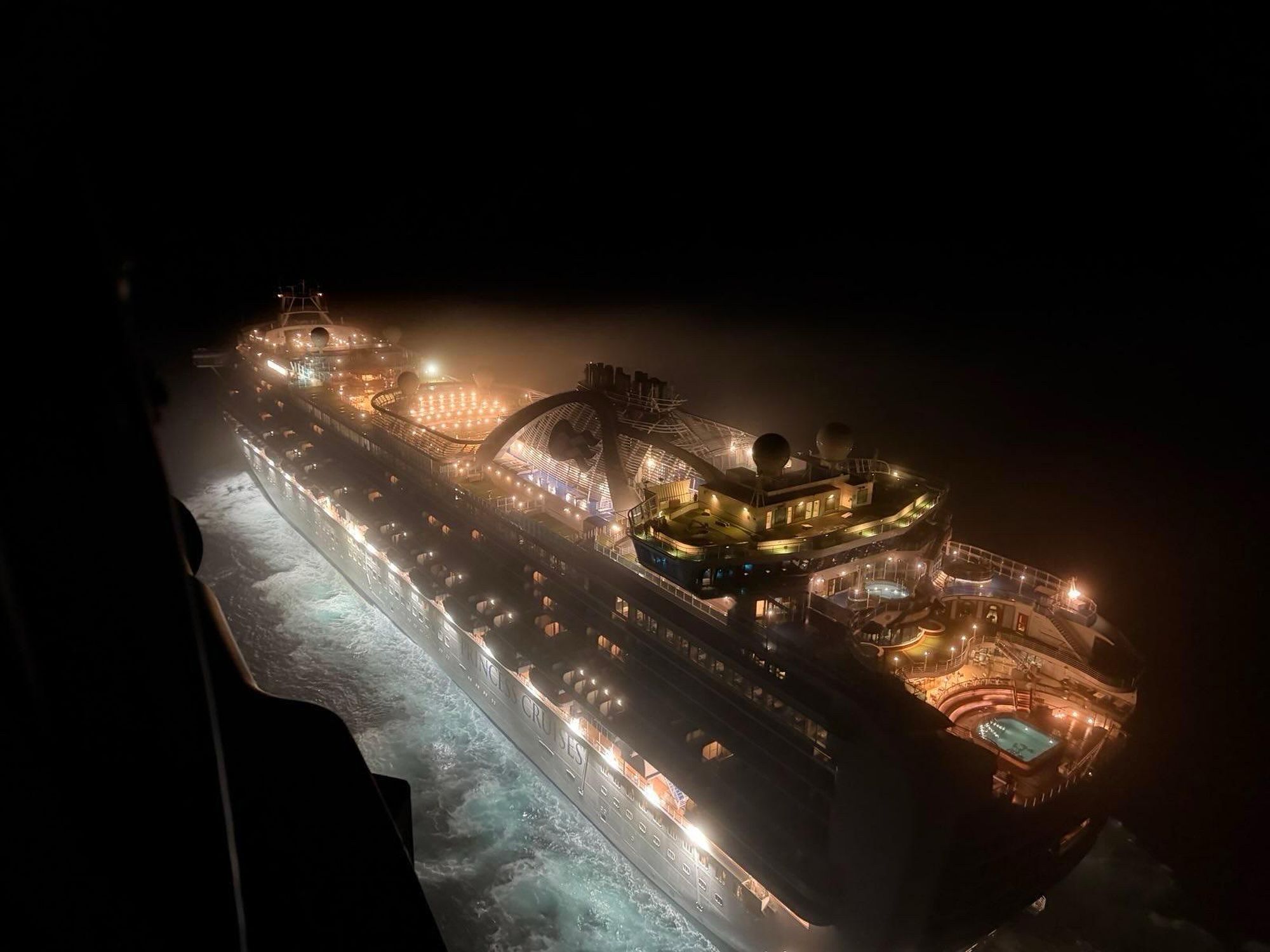 Aerial photo of the cruise ship against a pitch black sky.