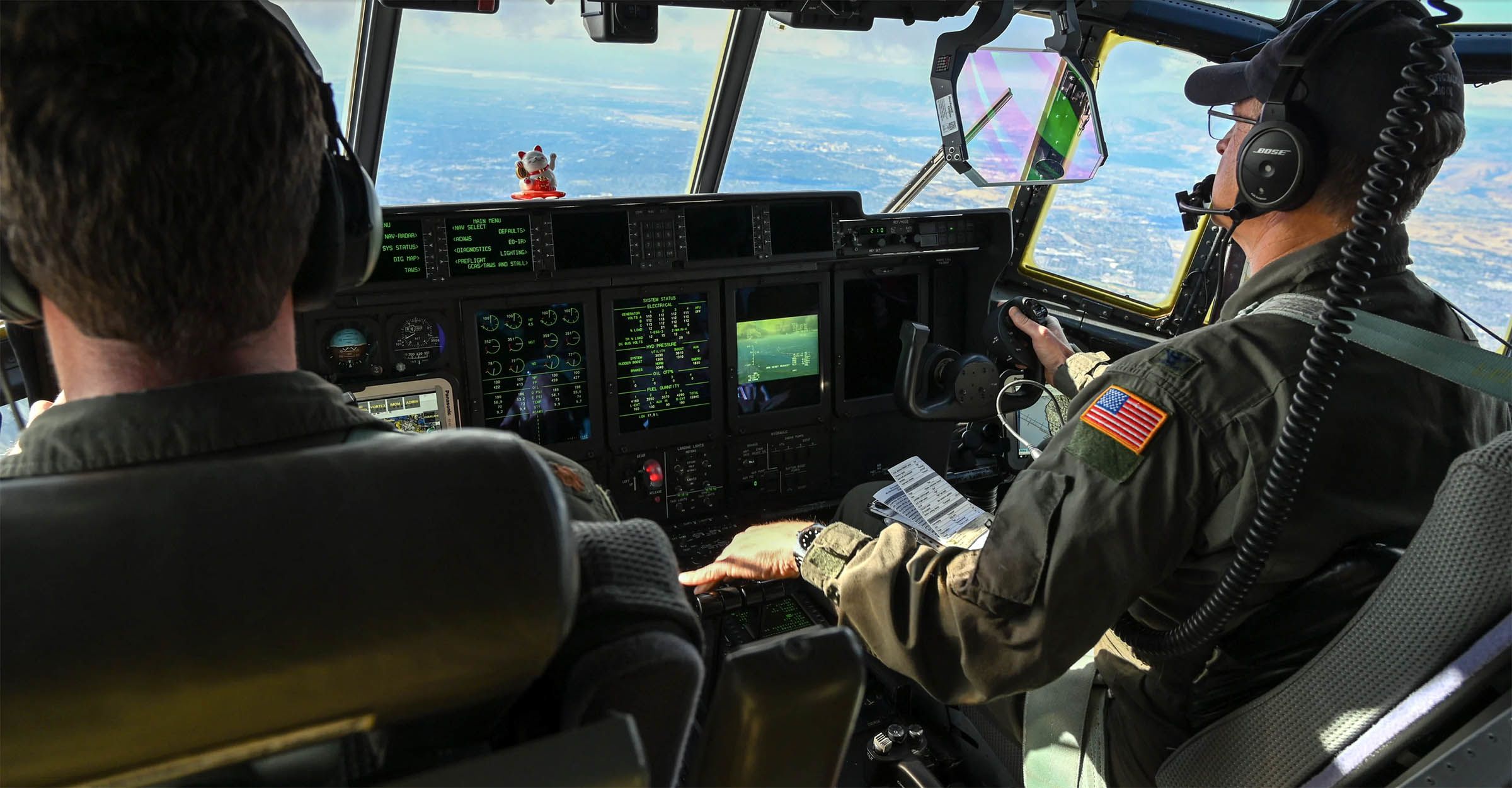 Pilots in HC-130J aircraft cockpit.