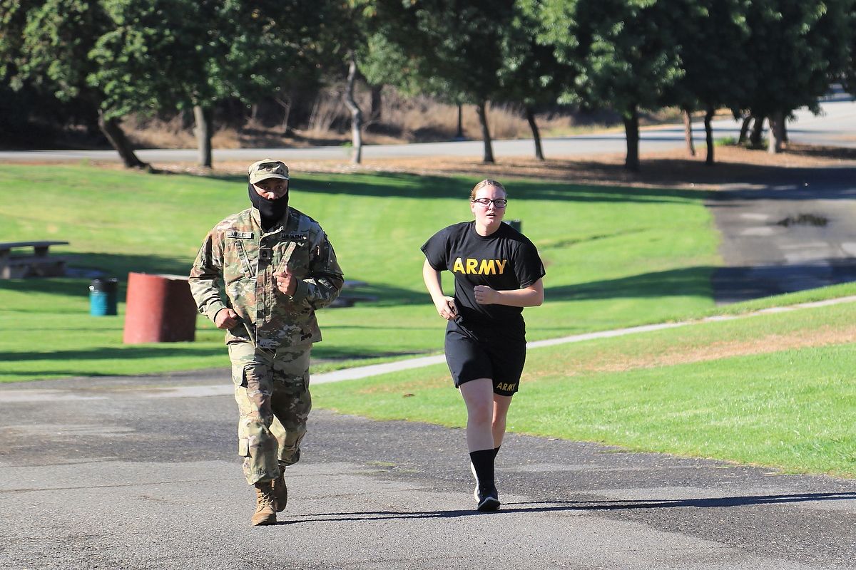 Two Soldiers run through park.