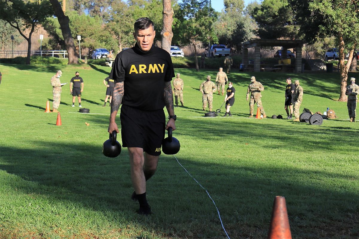 Soldier carries kettlebells.