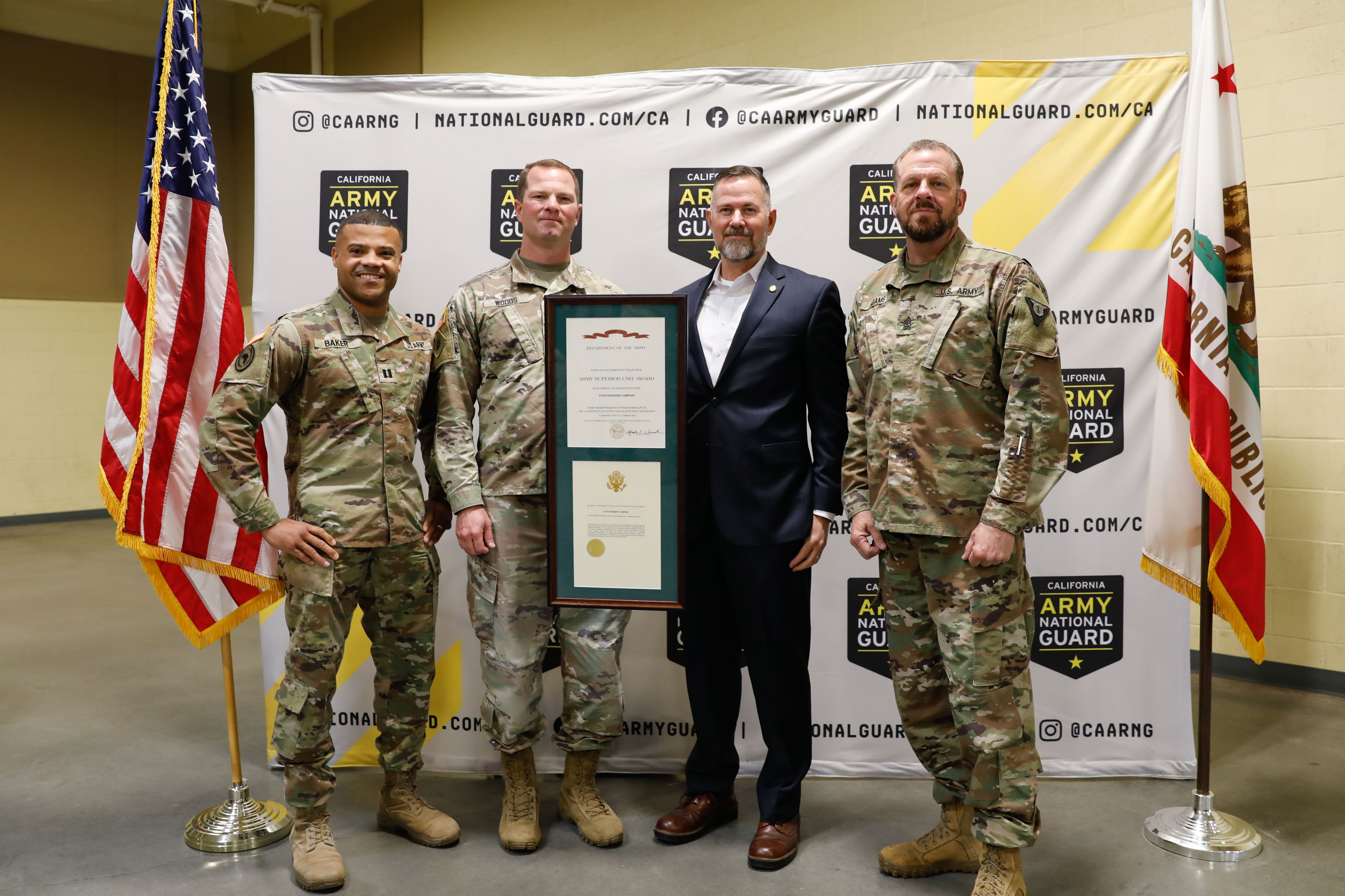 Three Soldiers stand in a group holding an award plaque
