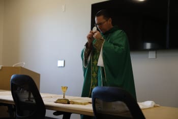 A chaplain holds up sacramental bread