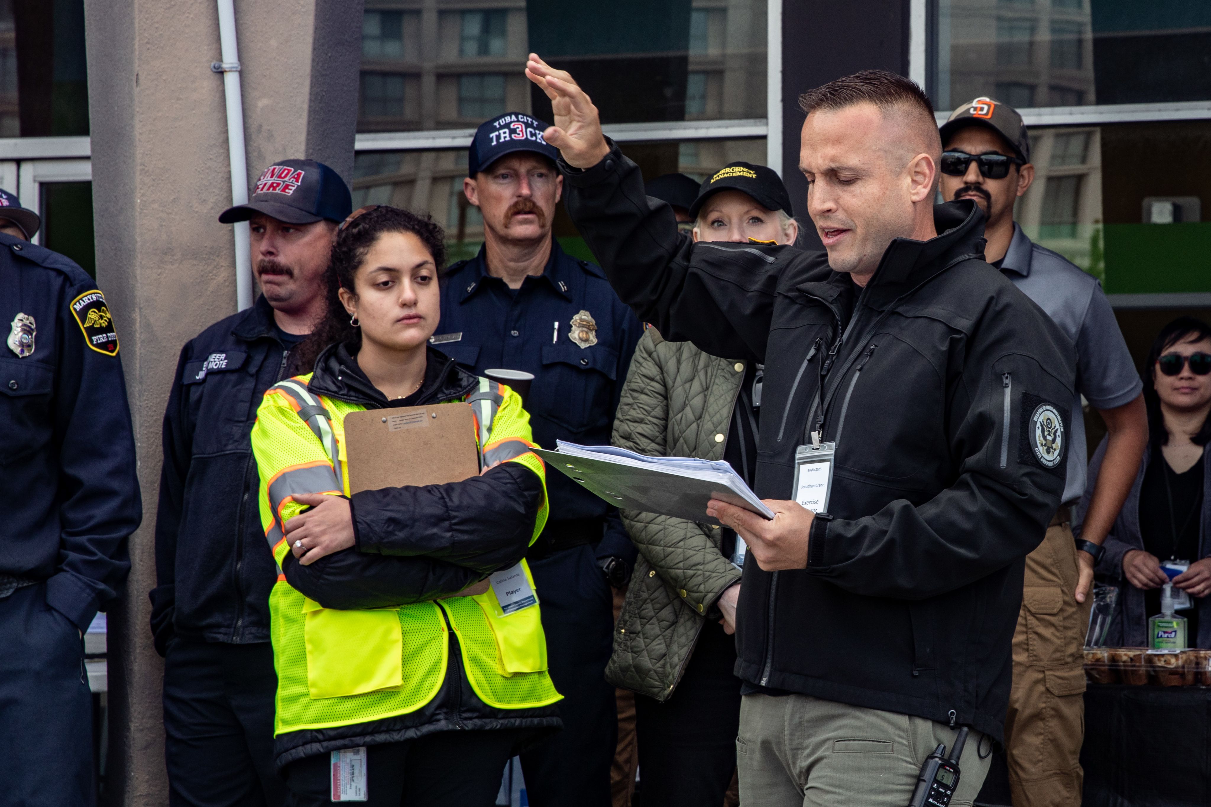 Service member wearing a black jacket speaks to a crowd