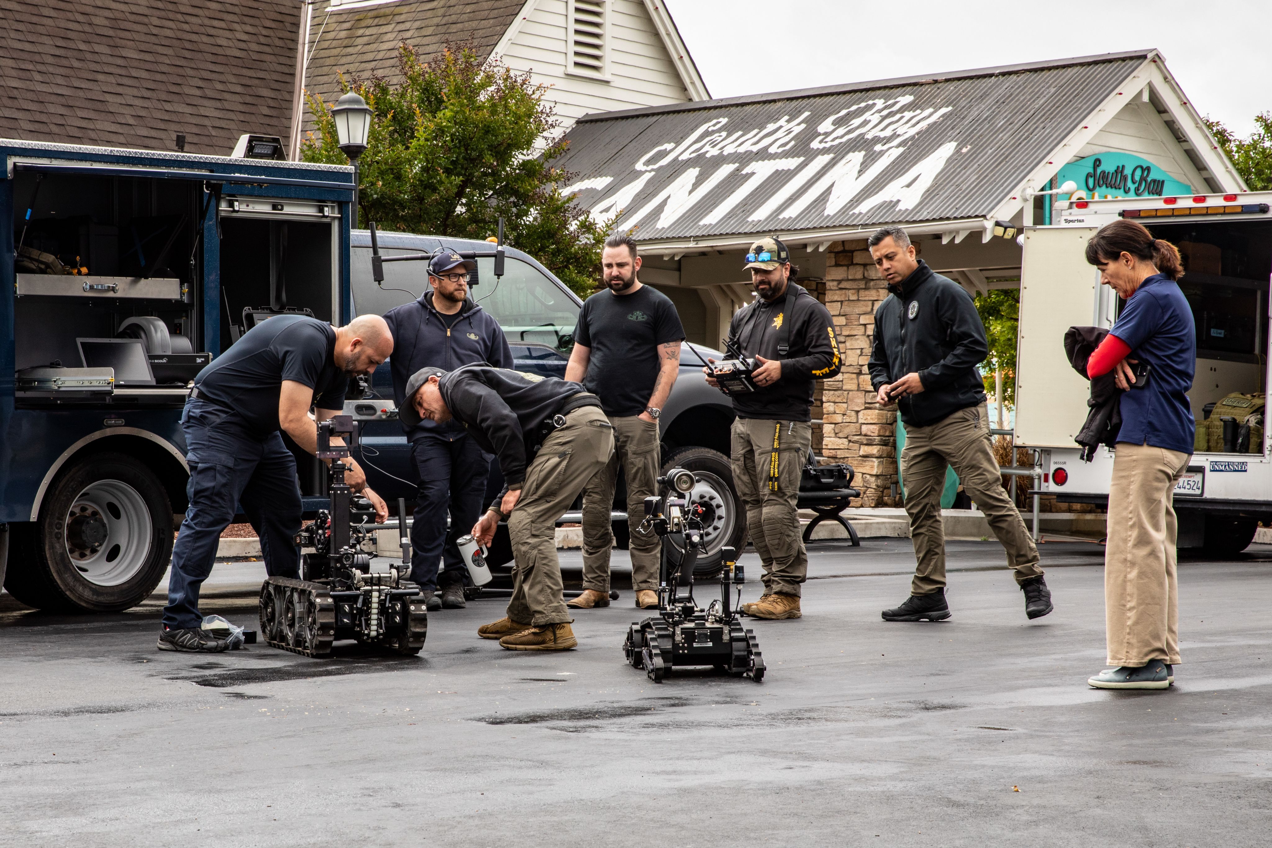 Service members examine a bomb robot
