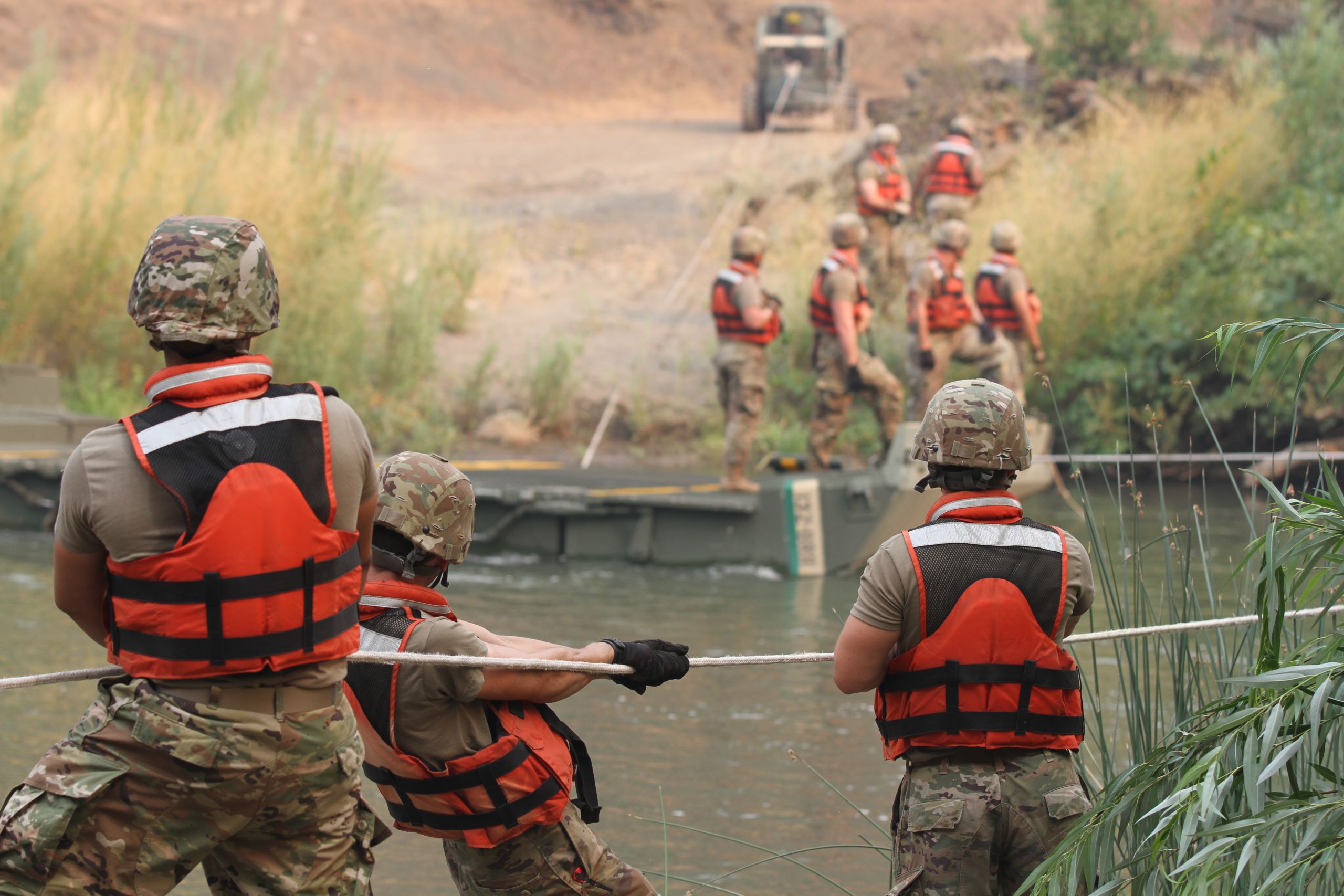 Soldiers secure bridge with ropes across Cache Creek River.