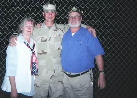 Soldier poses with parents before deploying to Iraq.