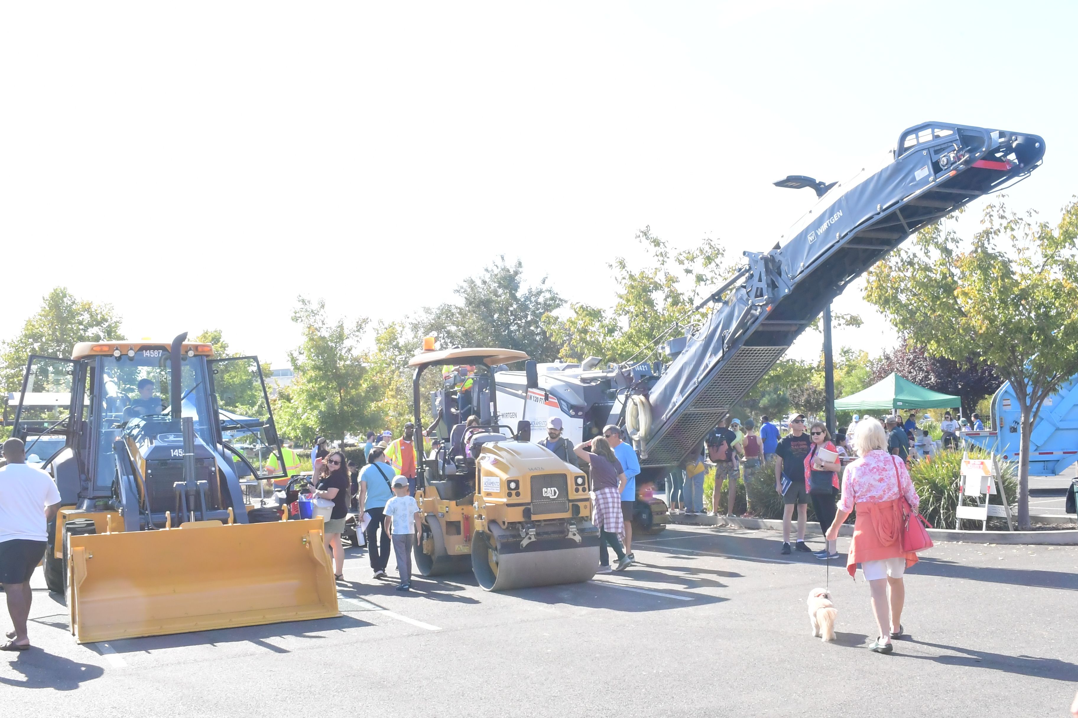 Families stand by construction, debris removal trucks