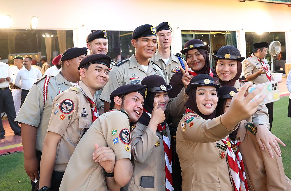 Teens in uniform take a group selfie photo.
