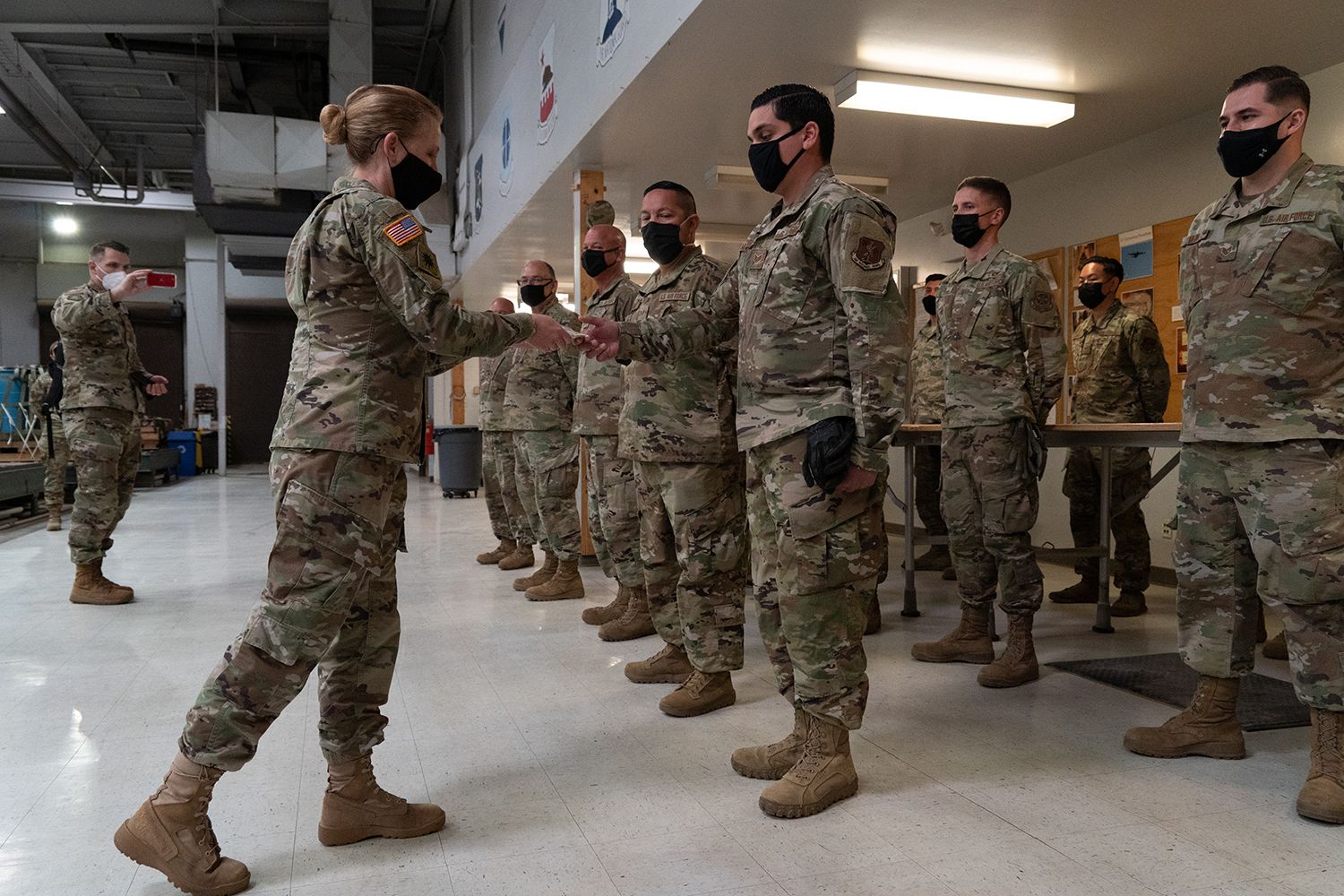General presents coin to service member.