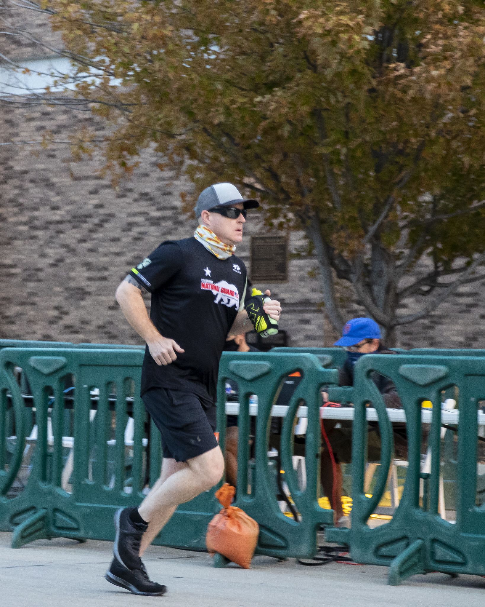Marathon runner runs past guard rail.