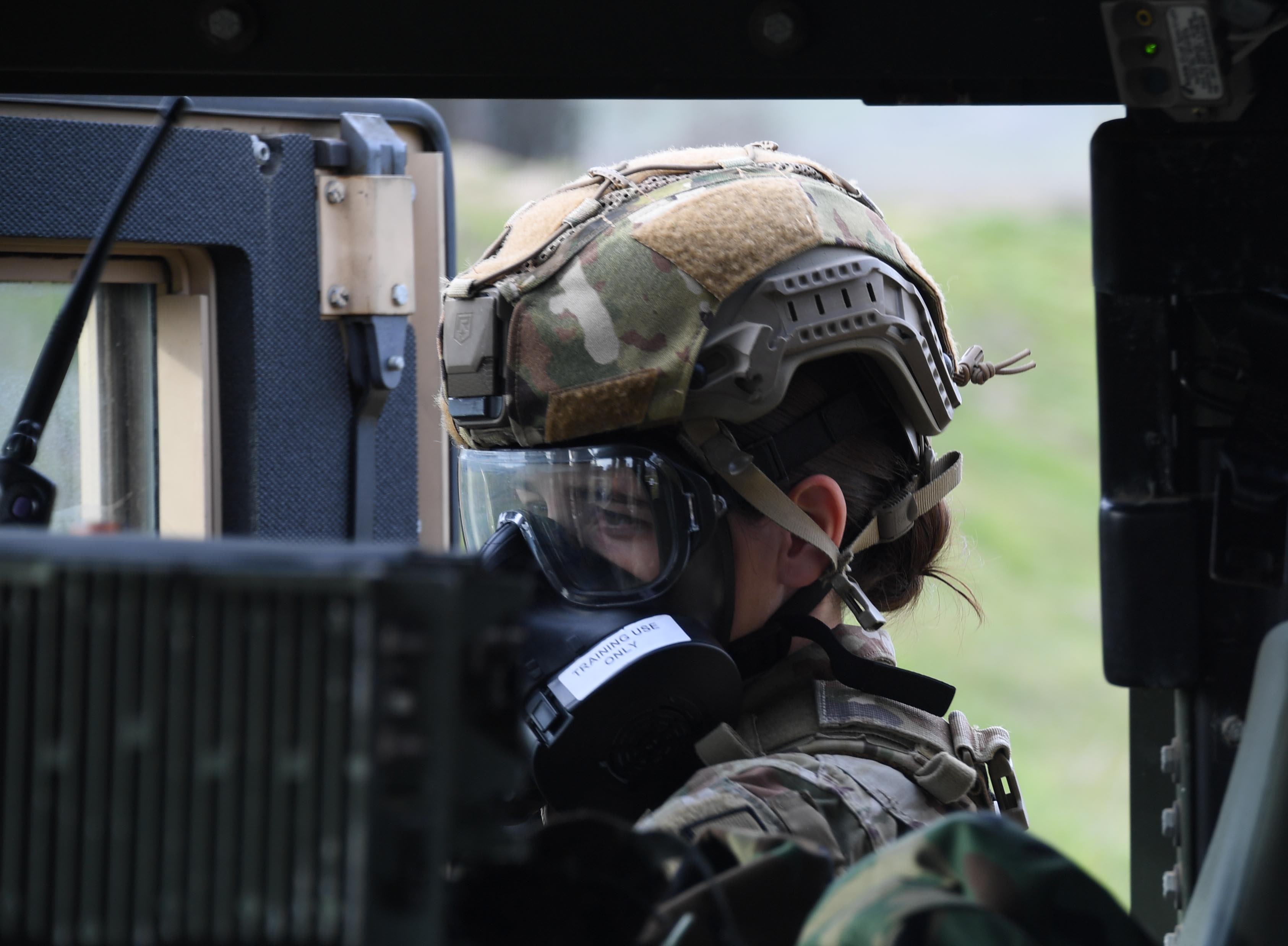 Female Airman puts on gas mask.