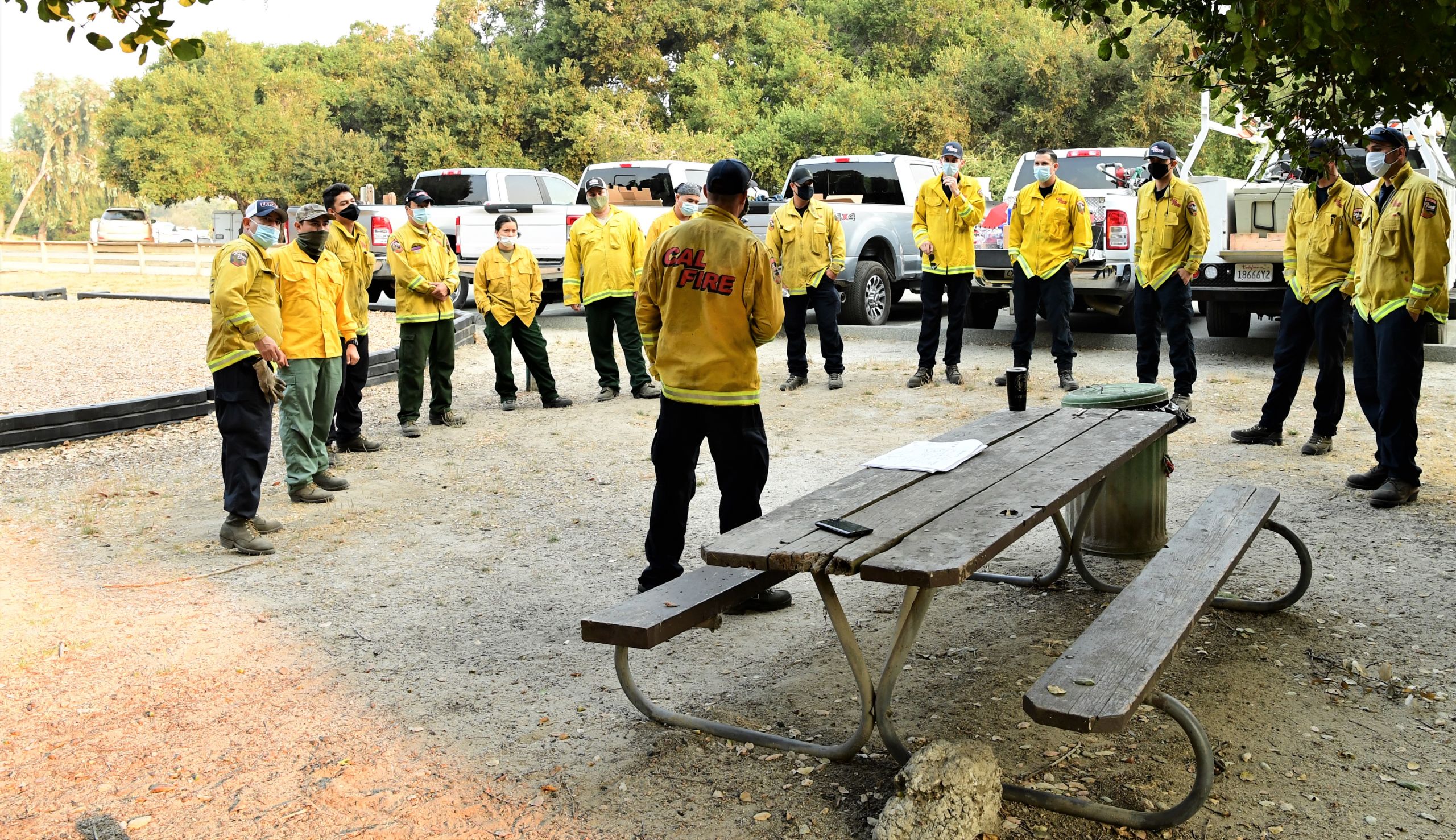 Group of service members listen to fire captain about the day's mission