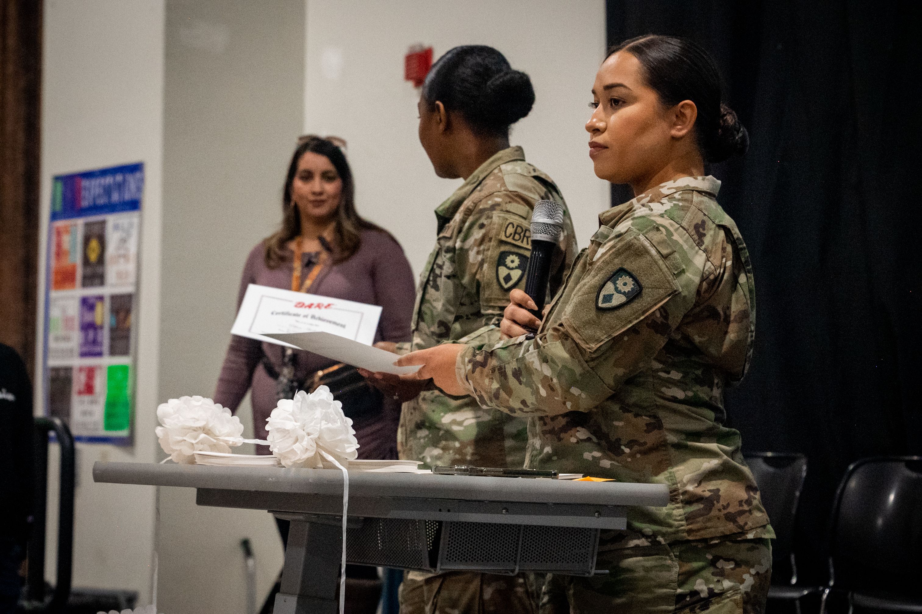 Two Soldiers speak during graduation ceremony