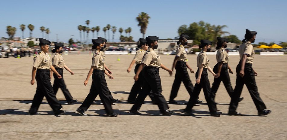 Female cadets march in formation.