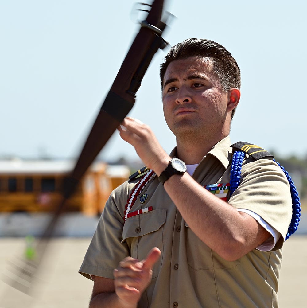 Teen in uniform spins rifle.