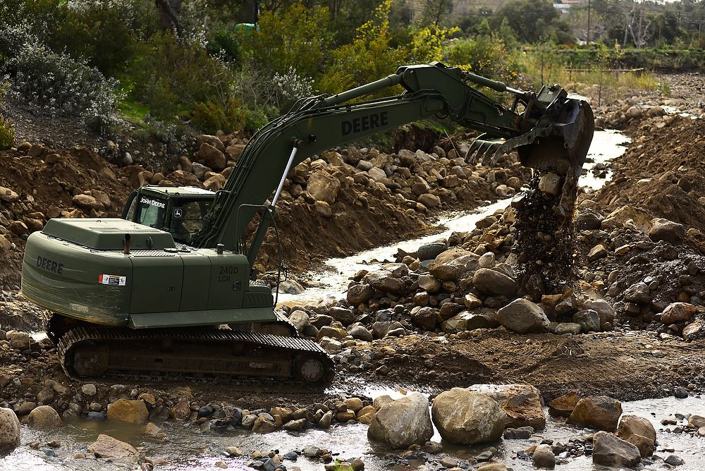 Heavy equipment excavator dumps rocks.