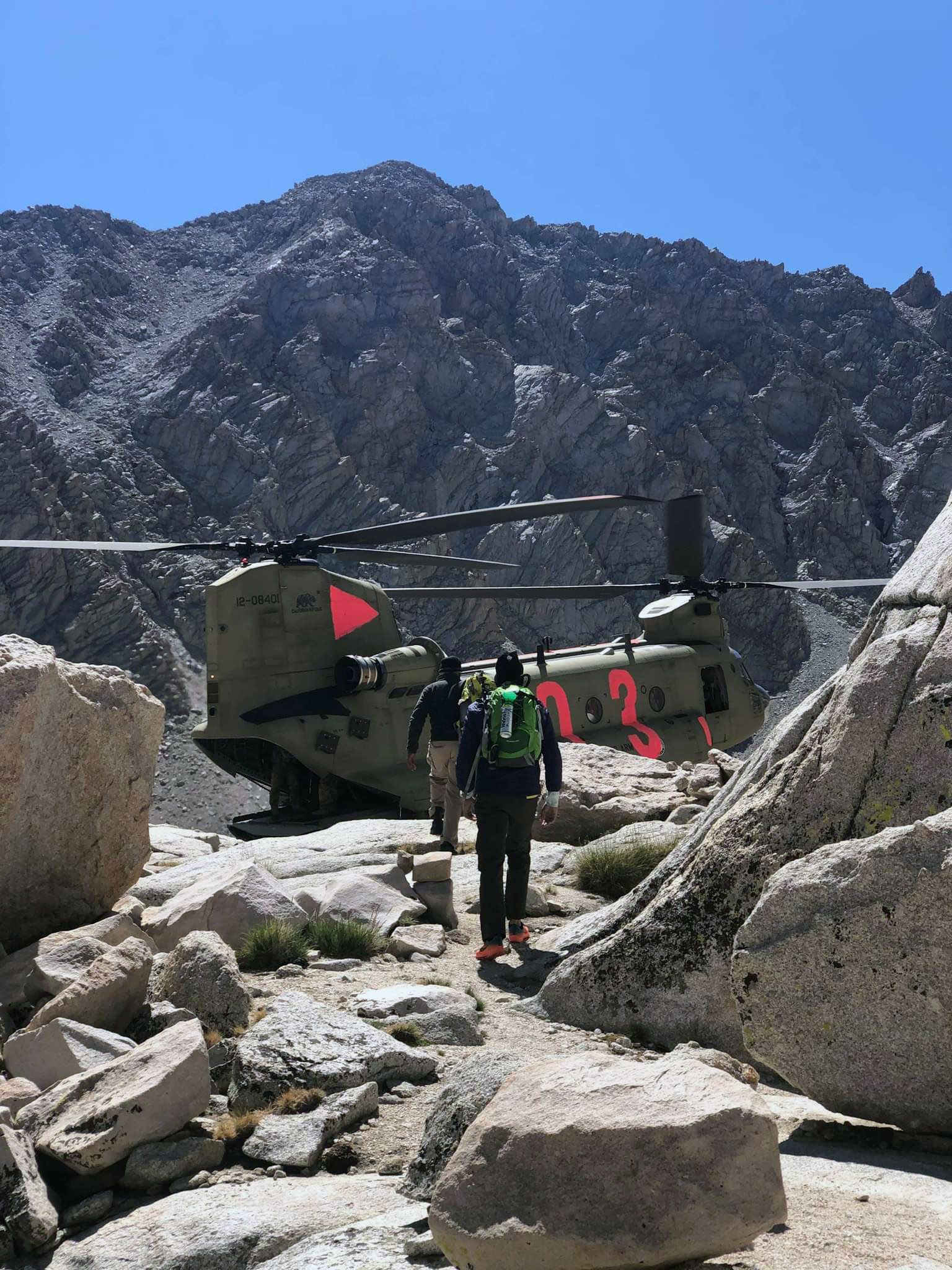 Helicopter partially landed on mountain.