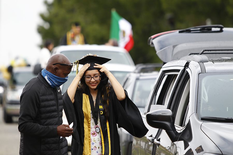 A student fixes her graduation cap on top of her head