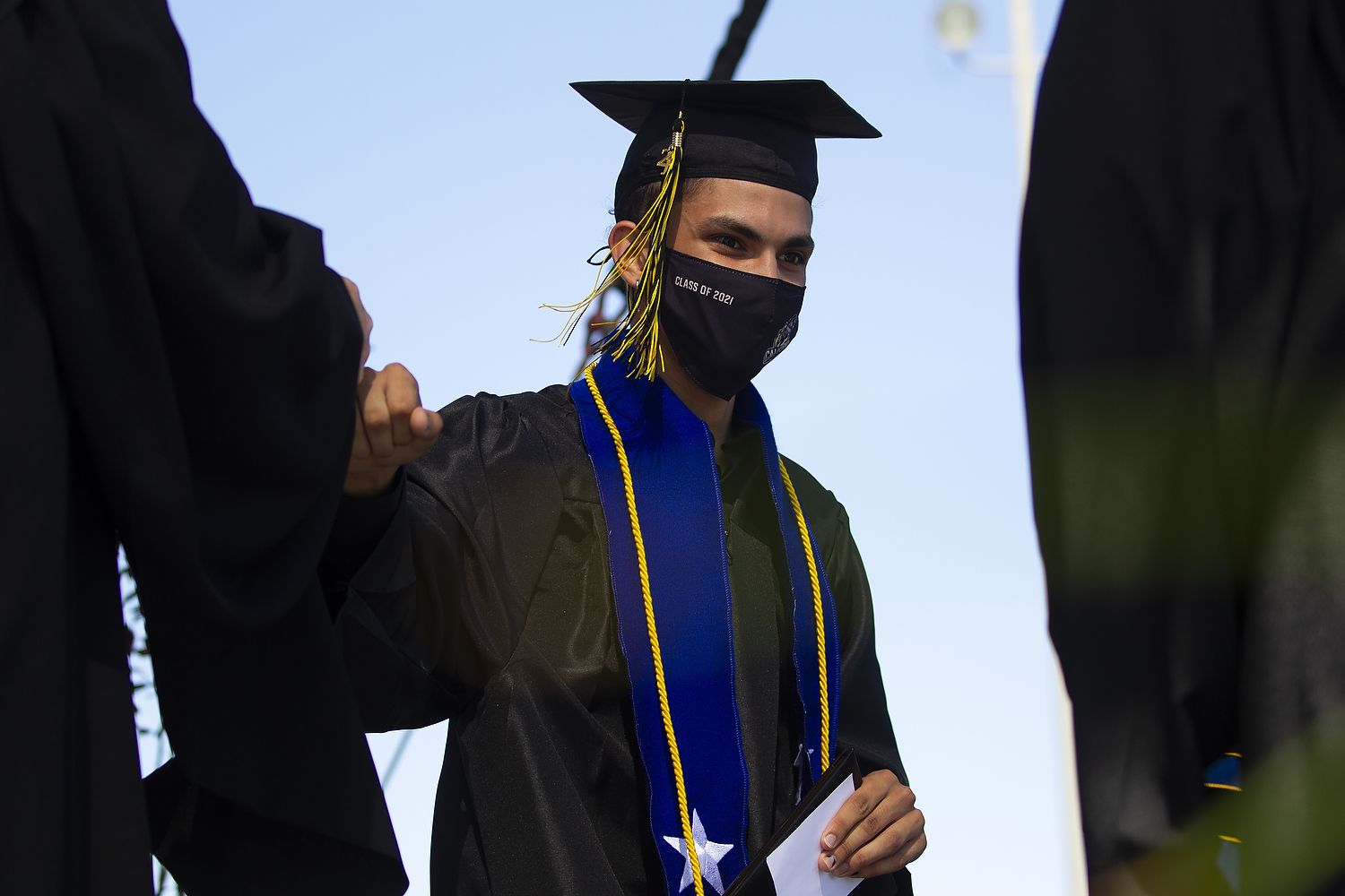Graduate fist-bumps someone.