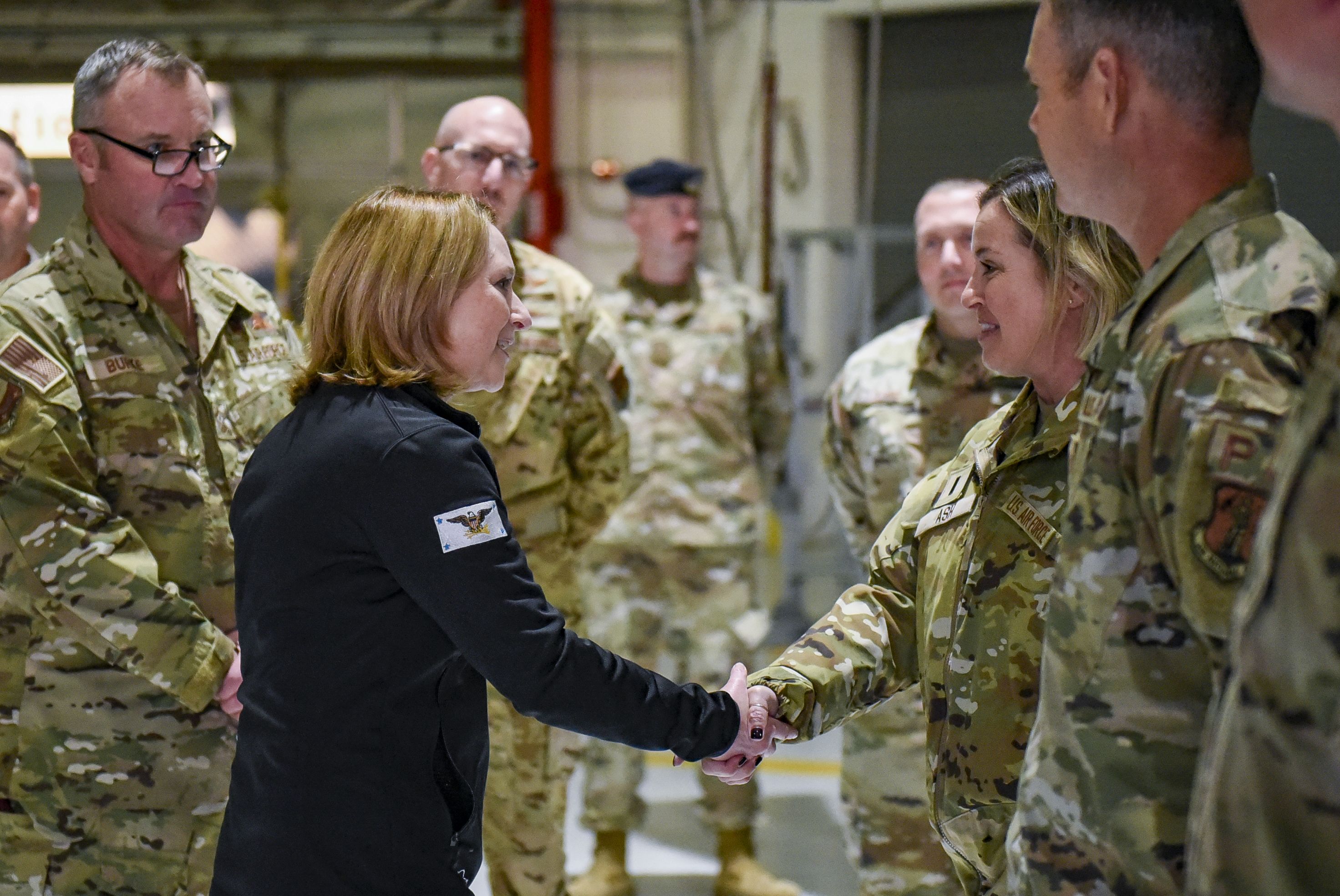 Man in suit talks to Airmen.