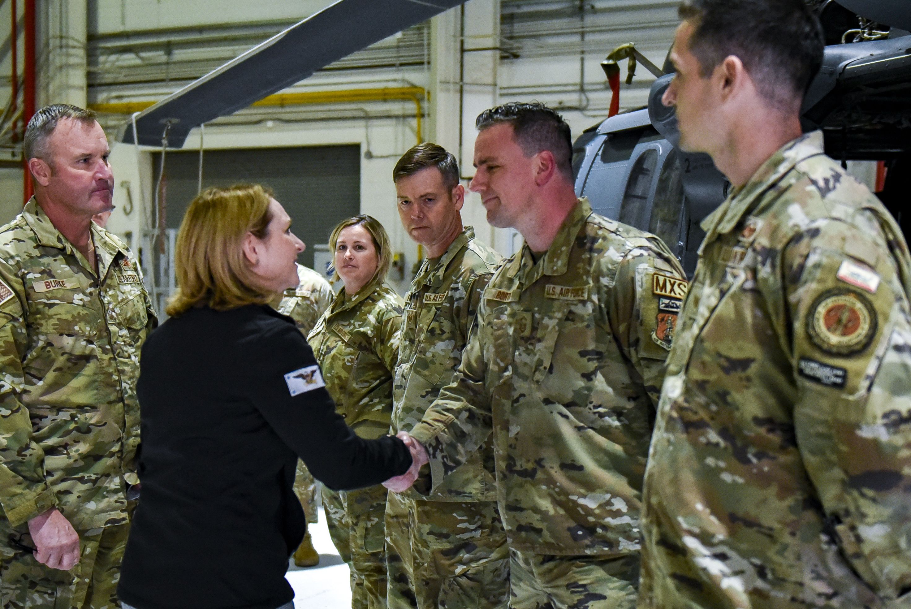 Man present coin to female Airman.