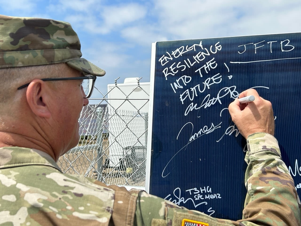 Soldier signs solar panel with marker