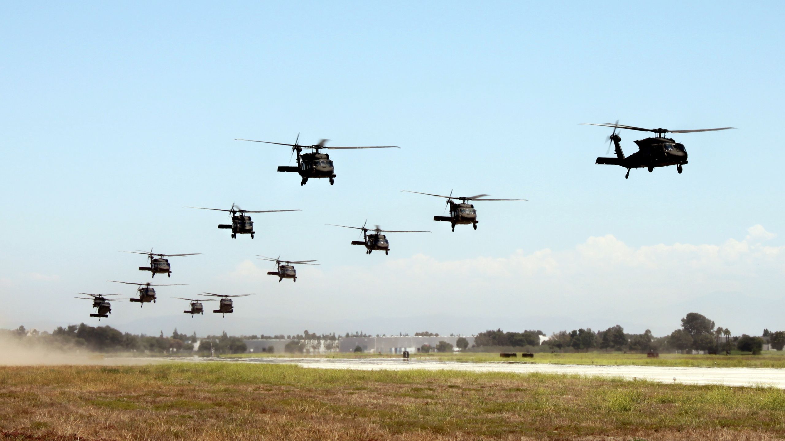 Twelve helicopters lifting off.