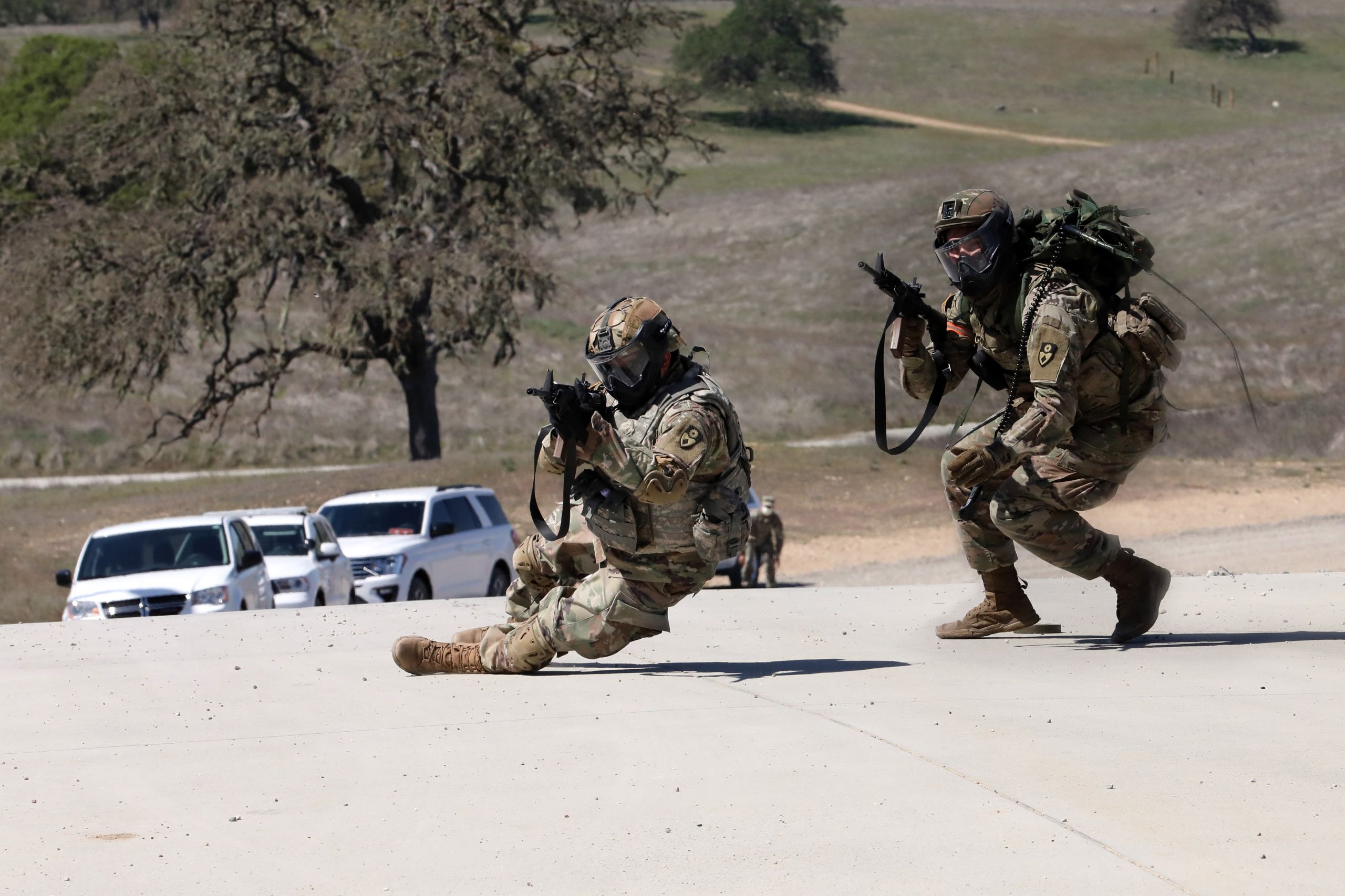 PICTURE OF TWO CAL GUARDSMEN RUNNING ON STREET