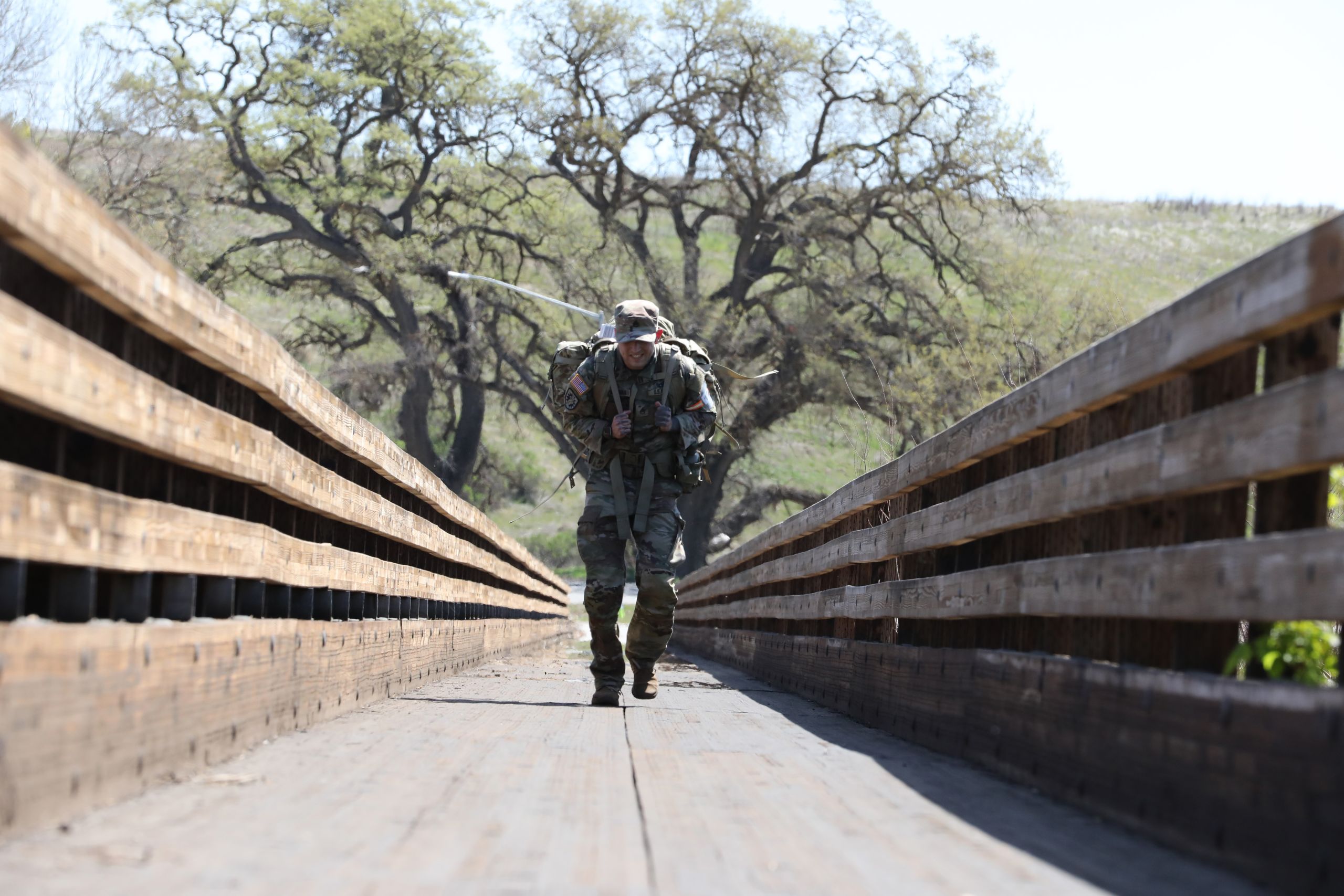 PHOTO OF CAL GUARDSMAN CROSSING BRIDGE CARRYING PACK
