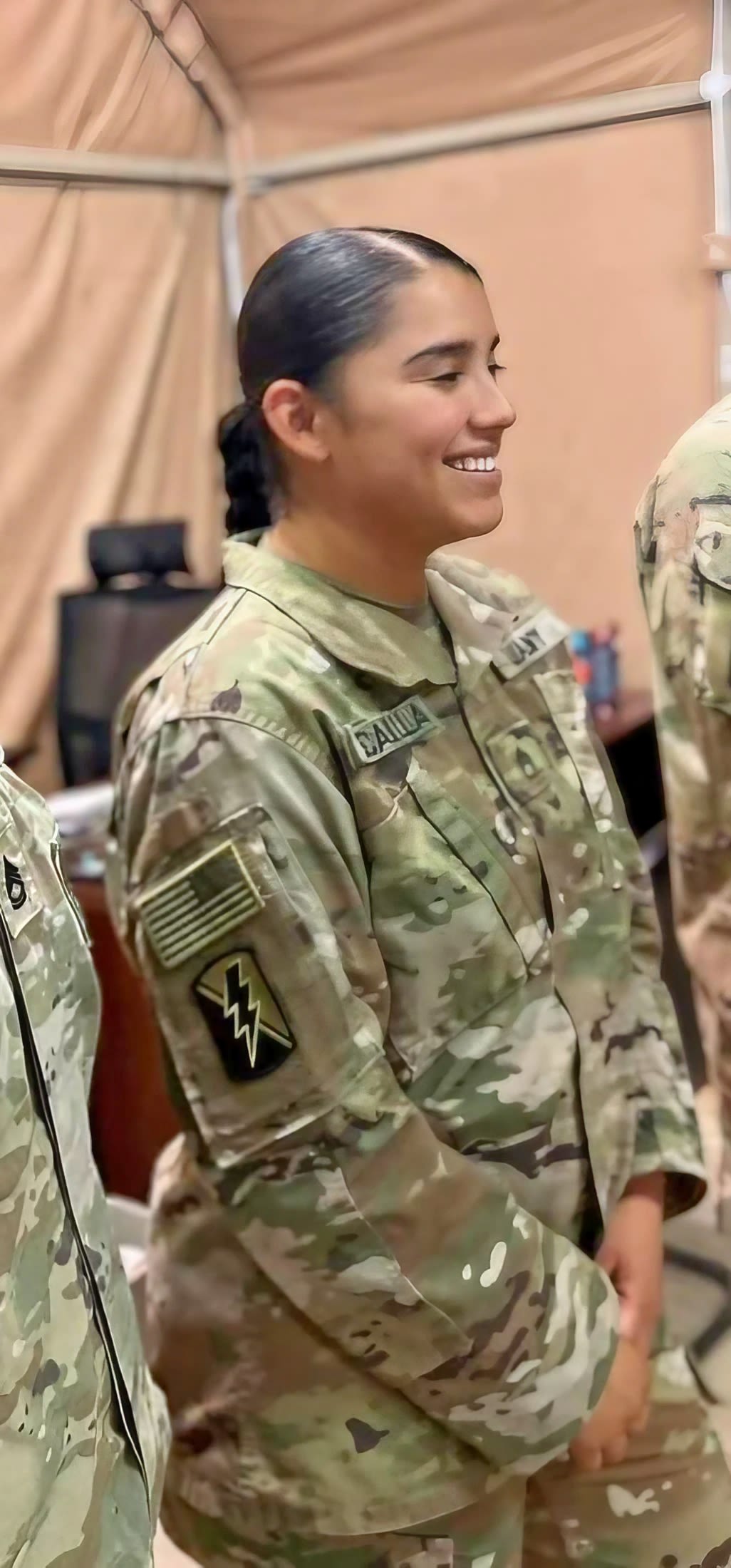 female soldier stands with group of soldiers