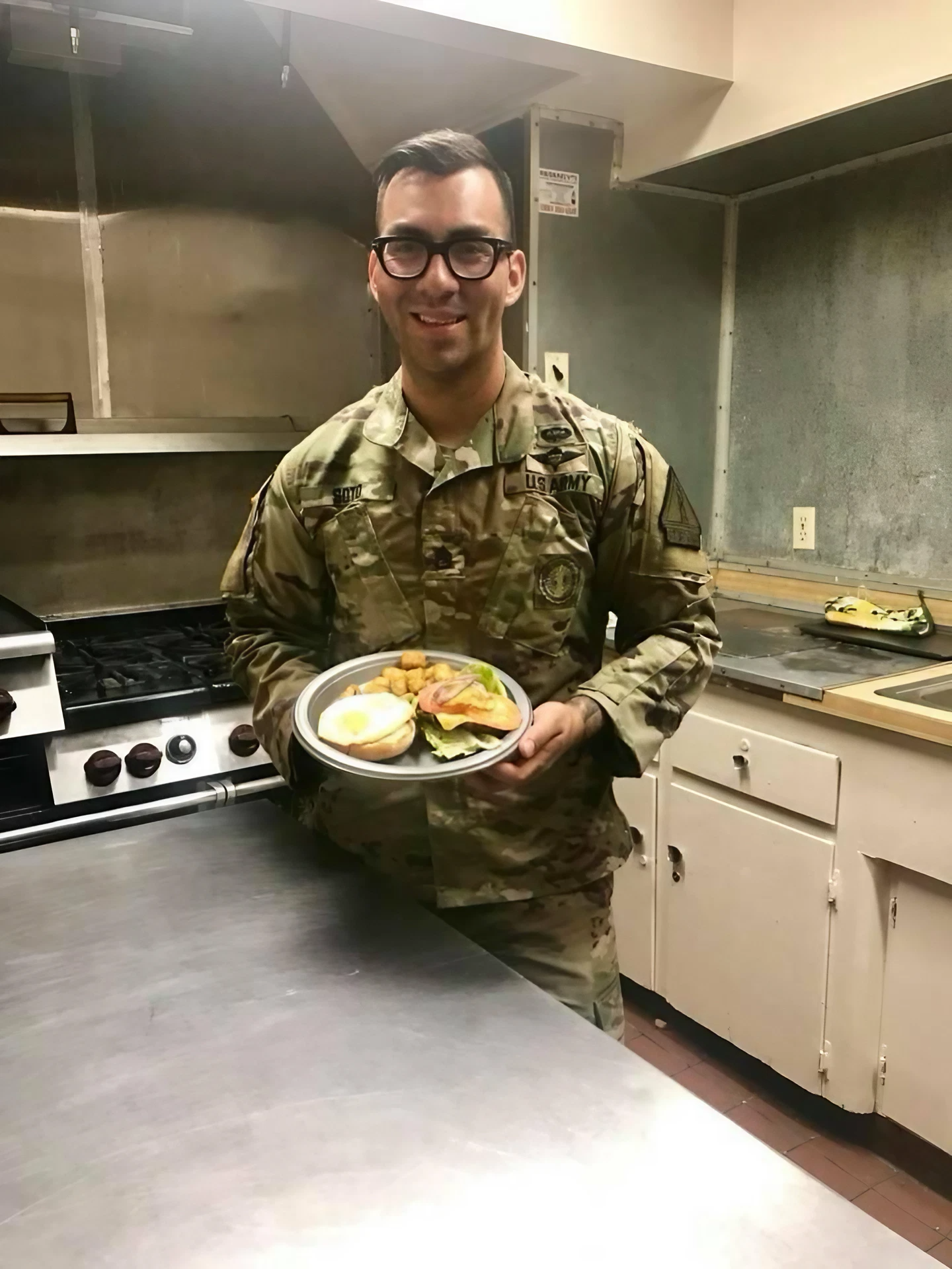Soldier stands in kitchen with a plate of food