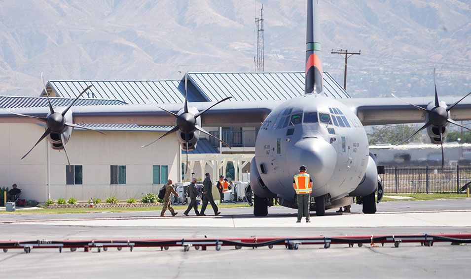 People walk to cargo plane on tarmac.