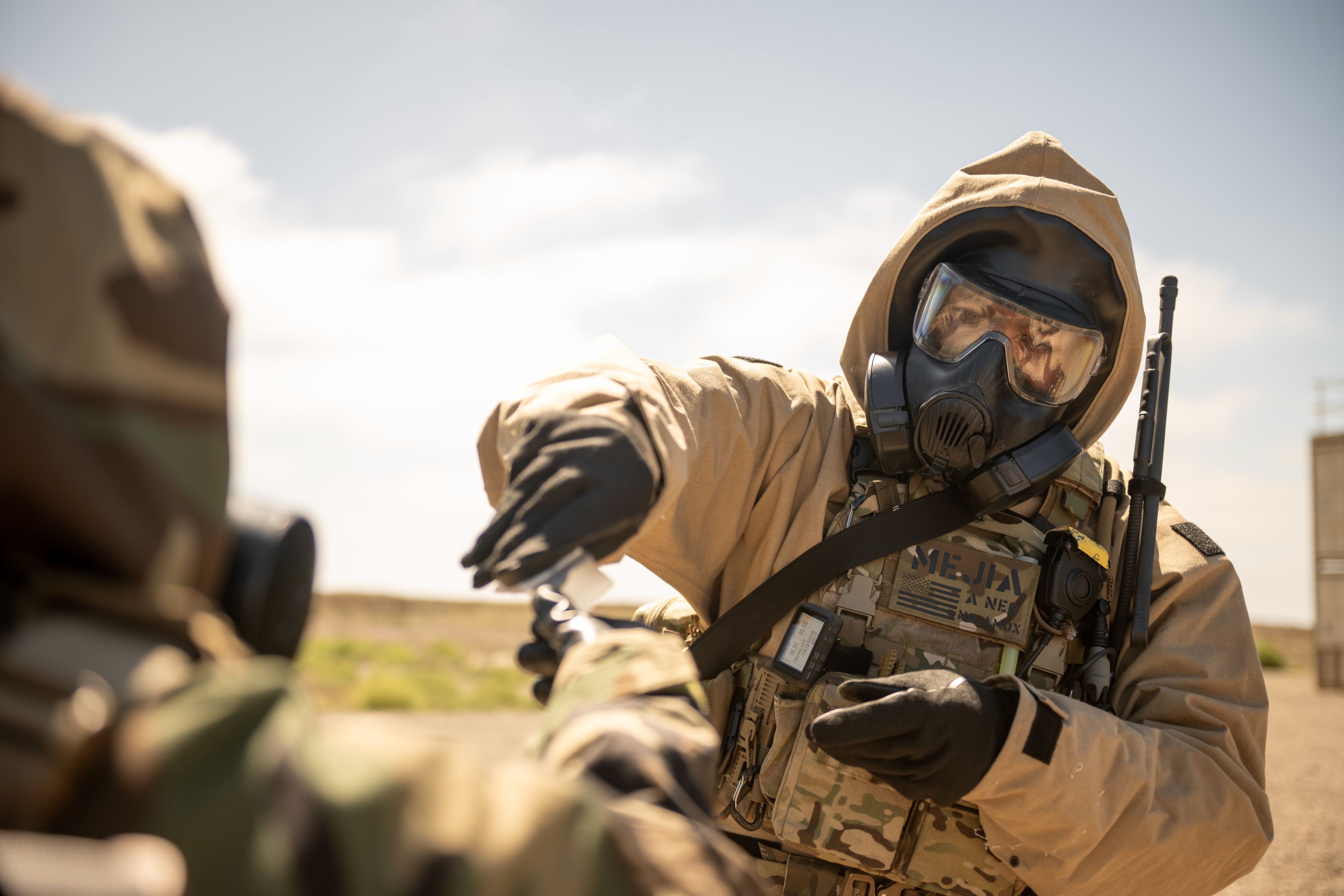Airman in HAZMAT suit collects soil samples