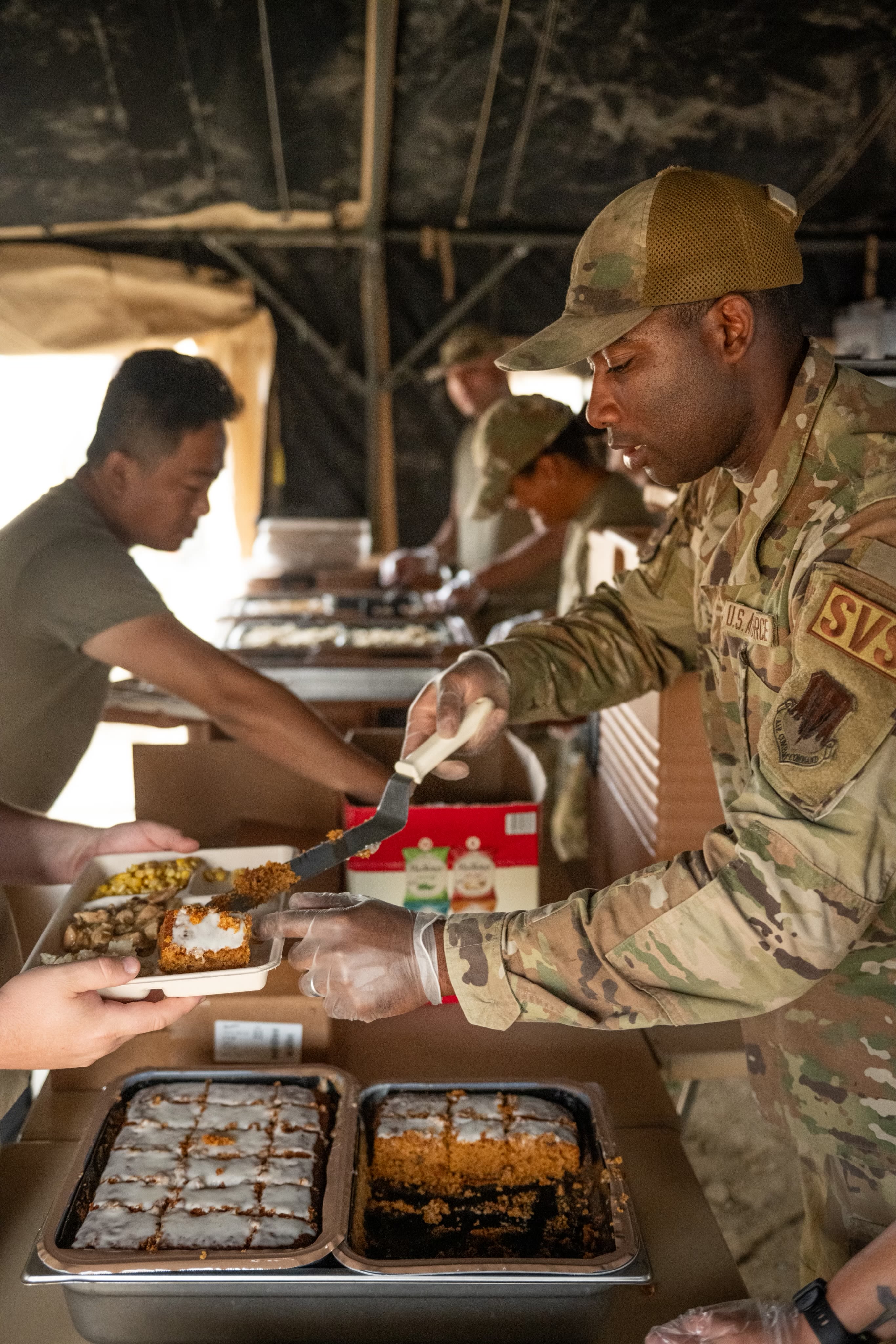 Airmen serves food to fellow airmen