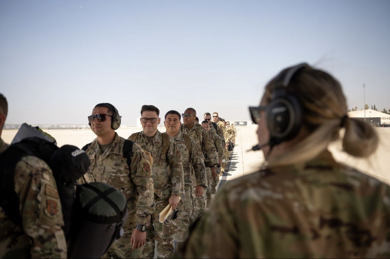 Airmen stand in line to board aircraft