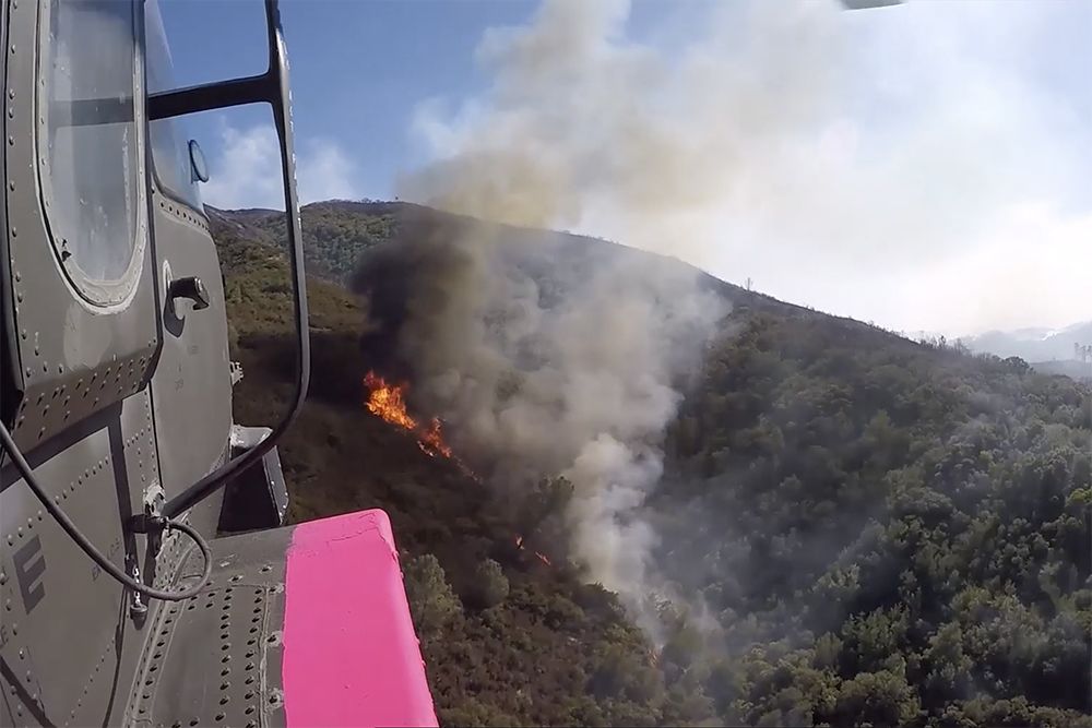 Helicopter flies over fire.
