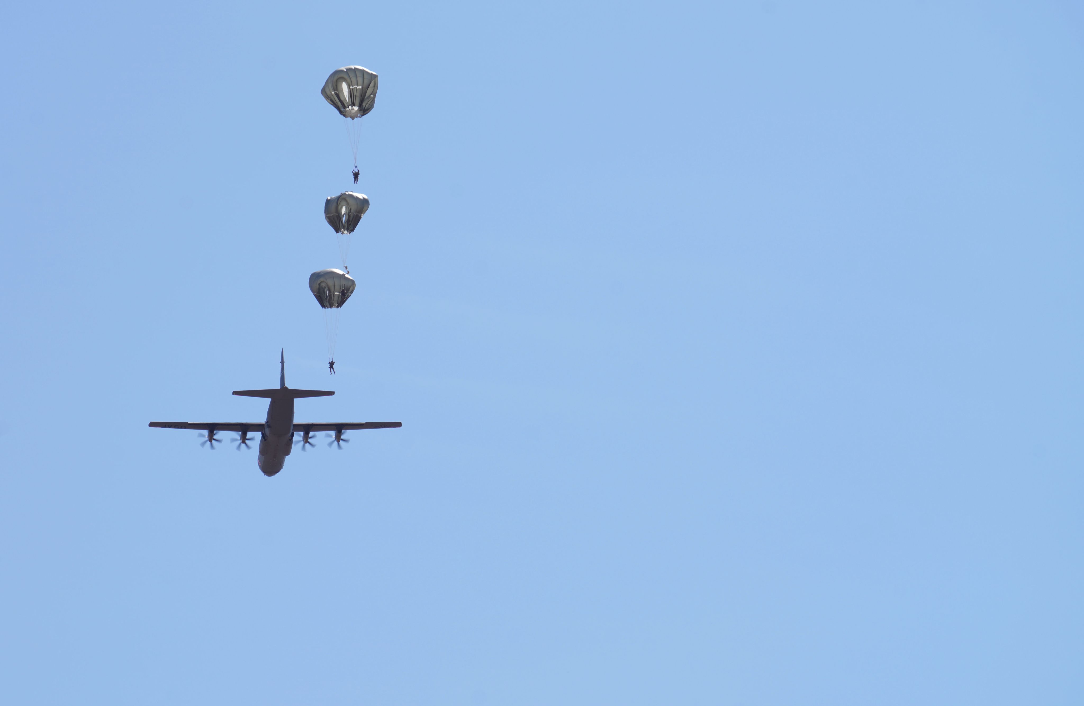 A C-130 drops parachutes
