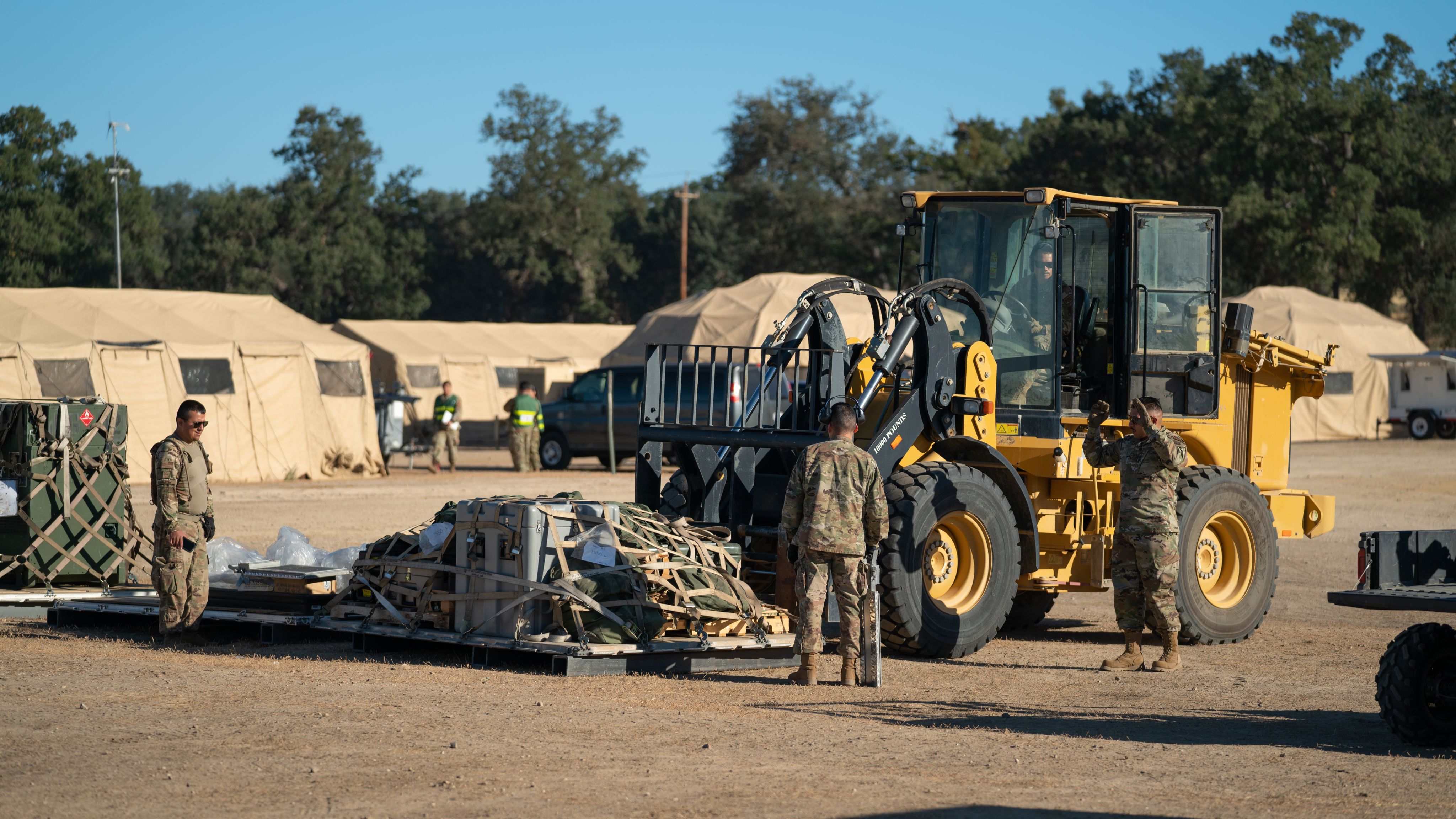 Airmen unpack a pallet from a forklift
