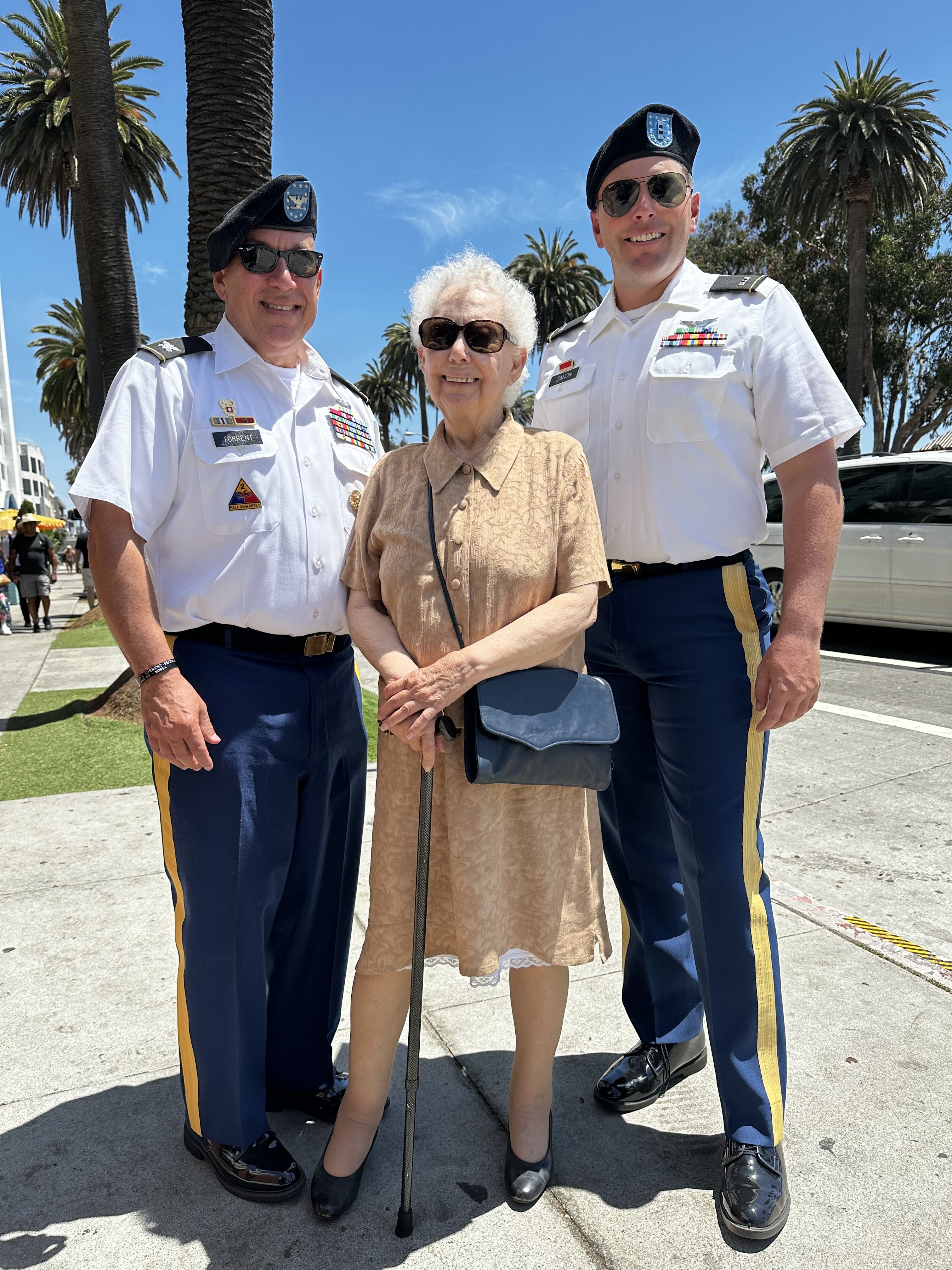 Two service members pose with woman