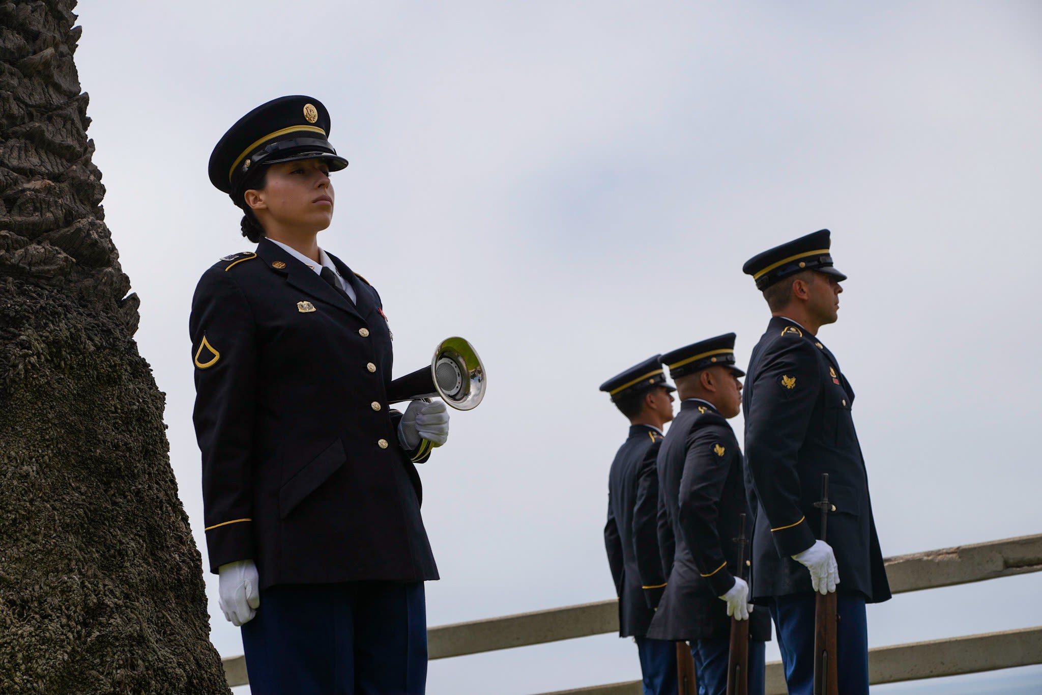 Four service members stand at attention 