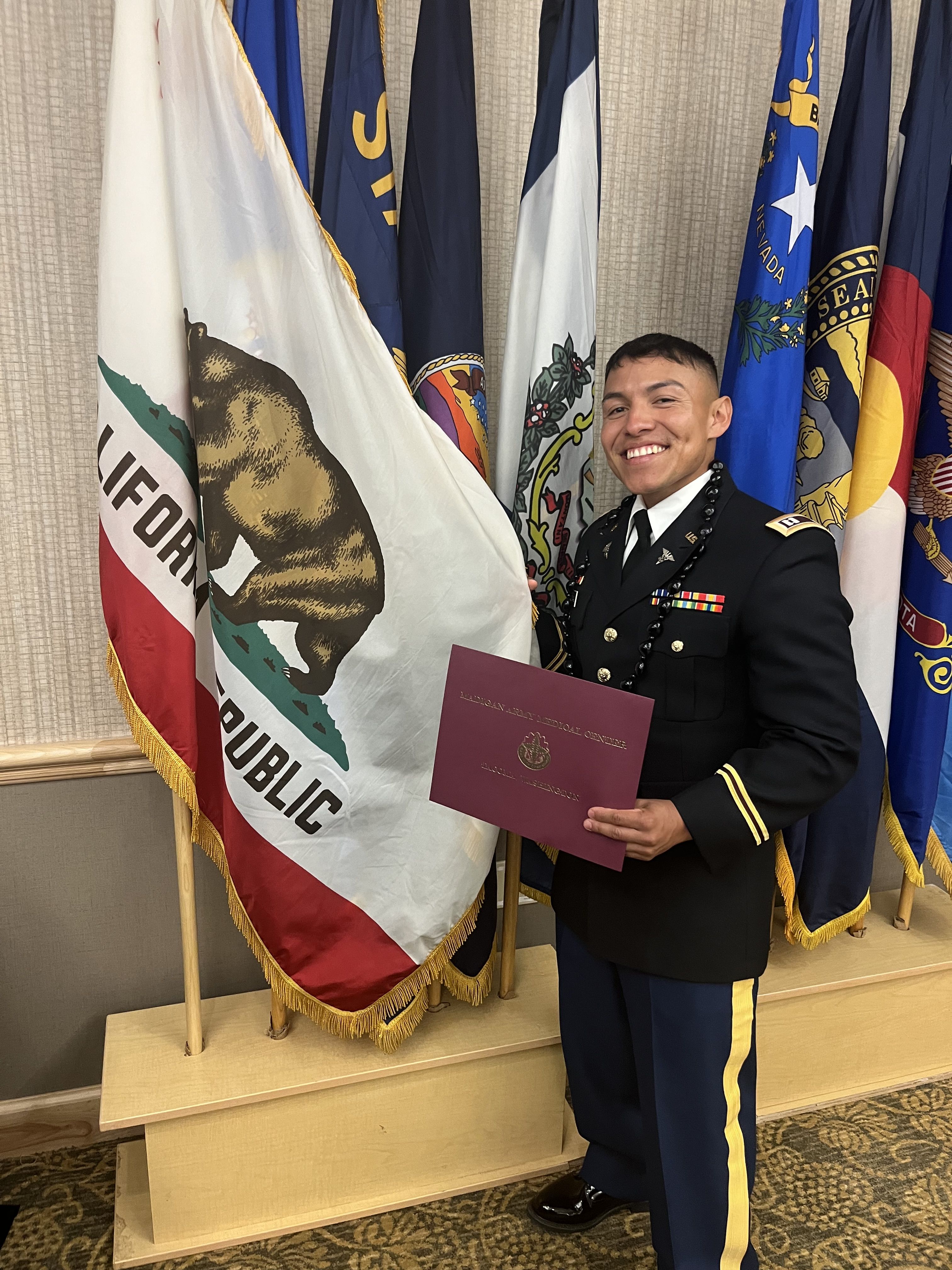 Soldier stands next to California state flag