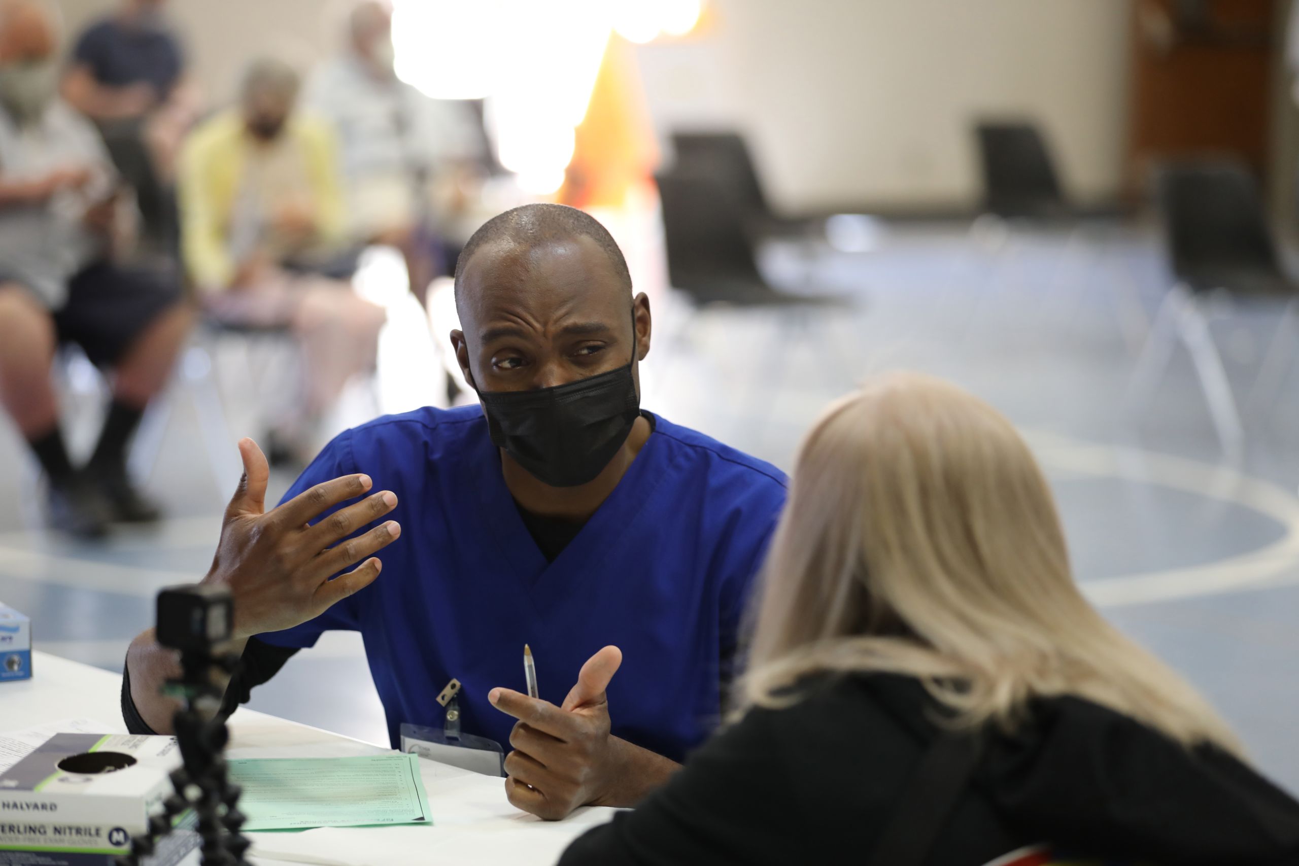 California National Guard medic instills vaccine.