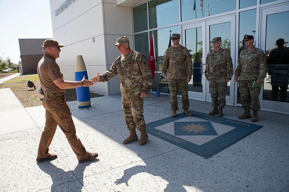 Men in uniforms shake hands.
