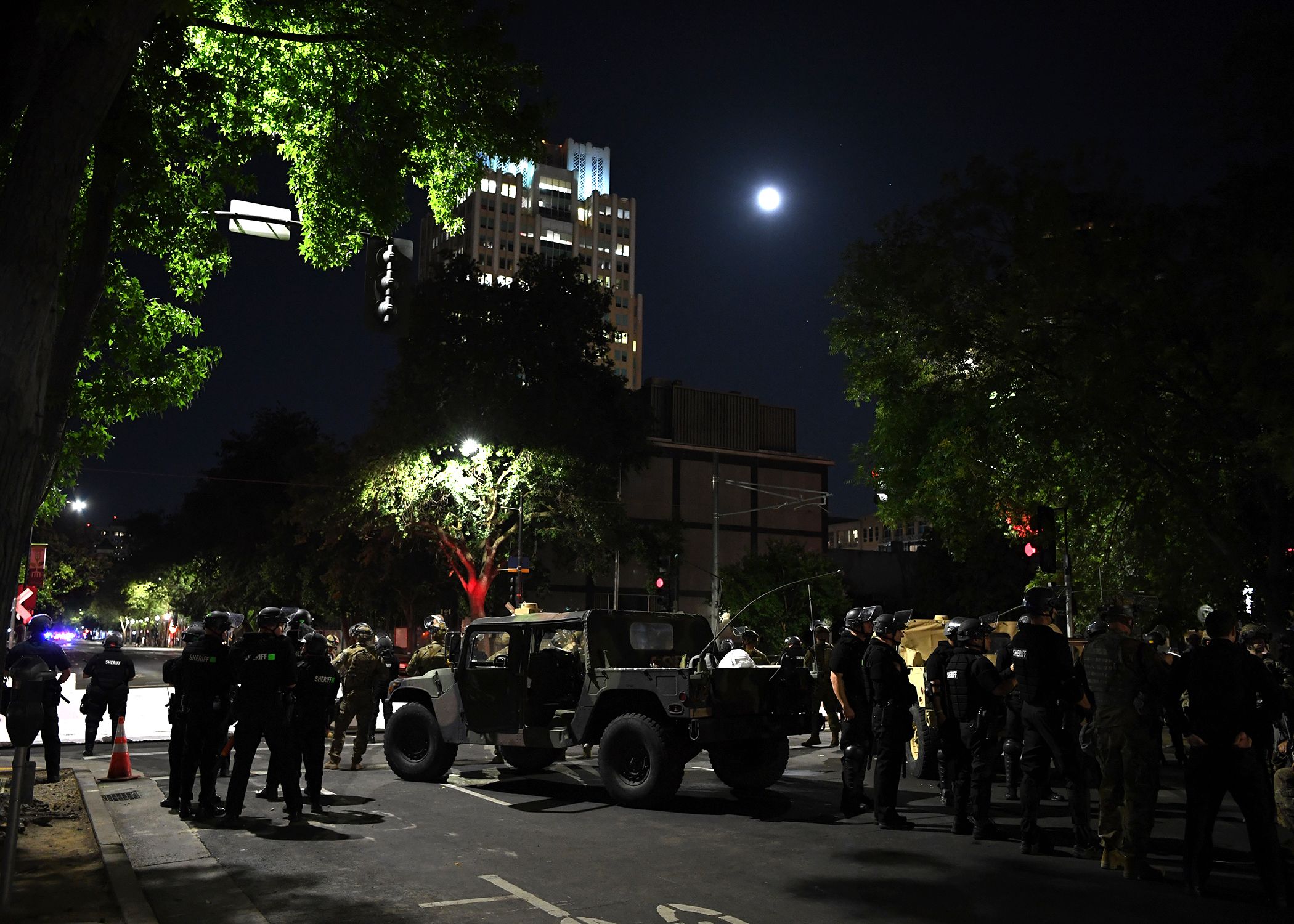 Soldiers and local law enforcement stand on city street