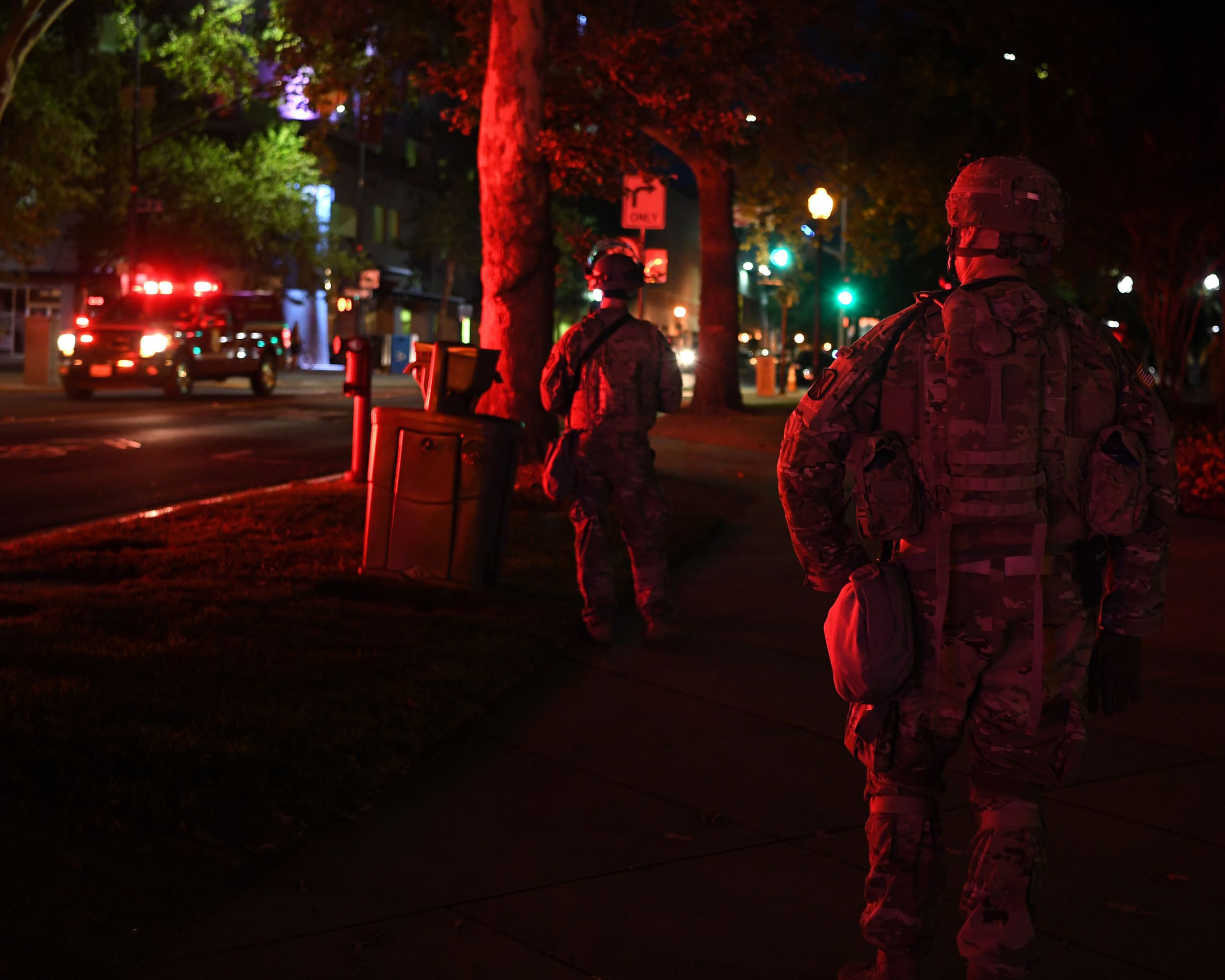 Soldiers watch emergency vehicles on streets of city