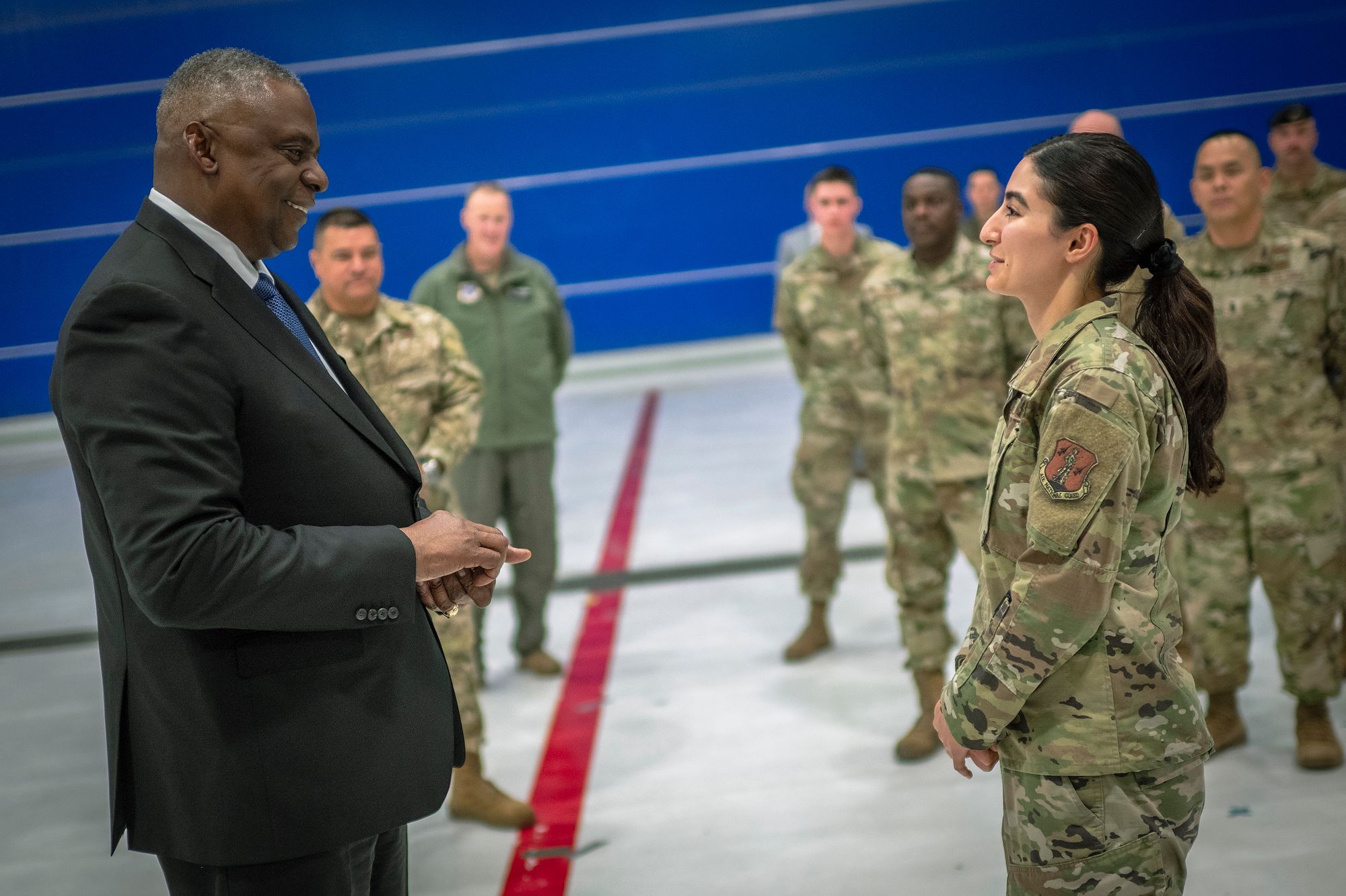 Man present coin to female Airman.