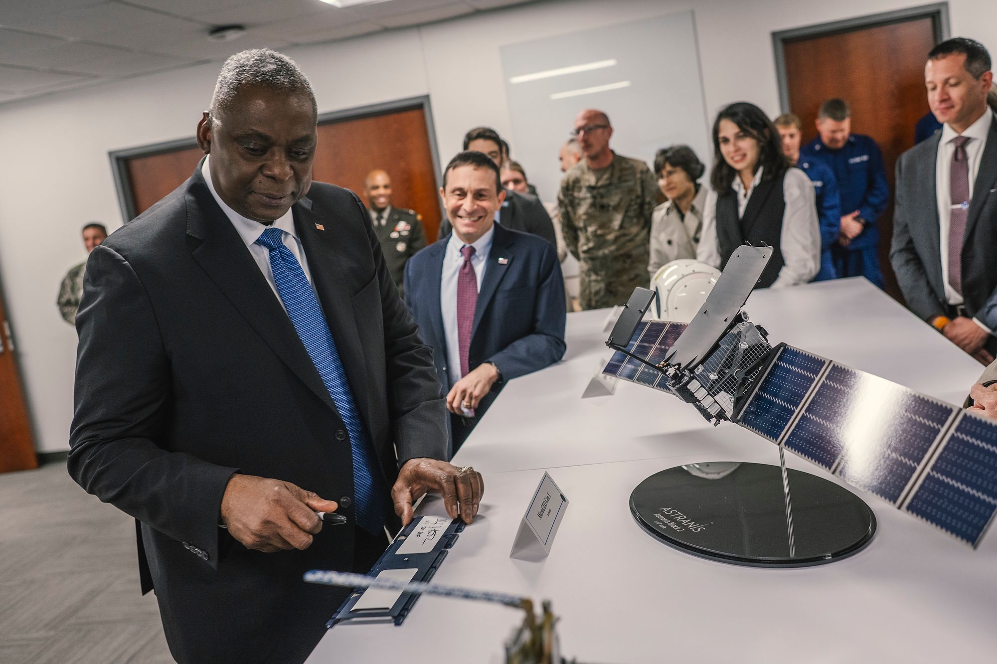 Man looks at satellite model with solar panels.