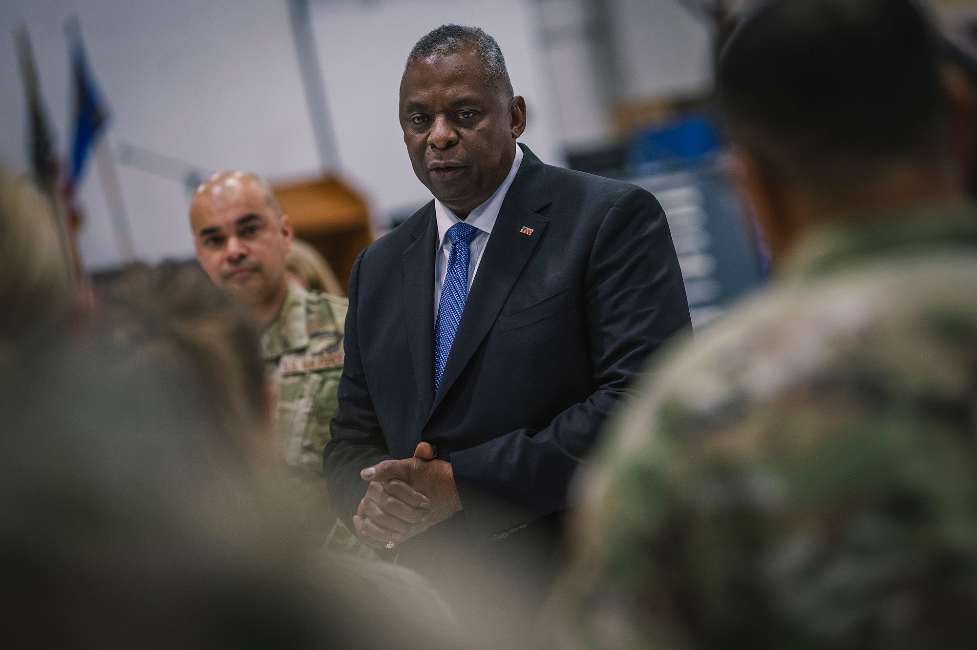 Man in suit talks to Airmen.