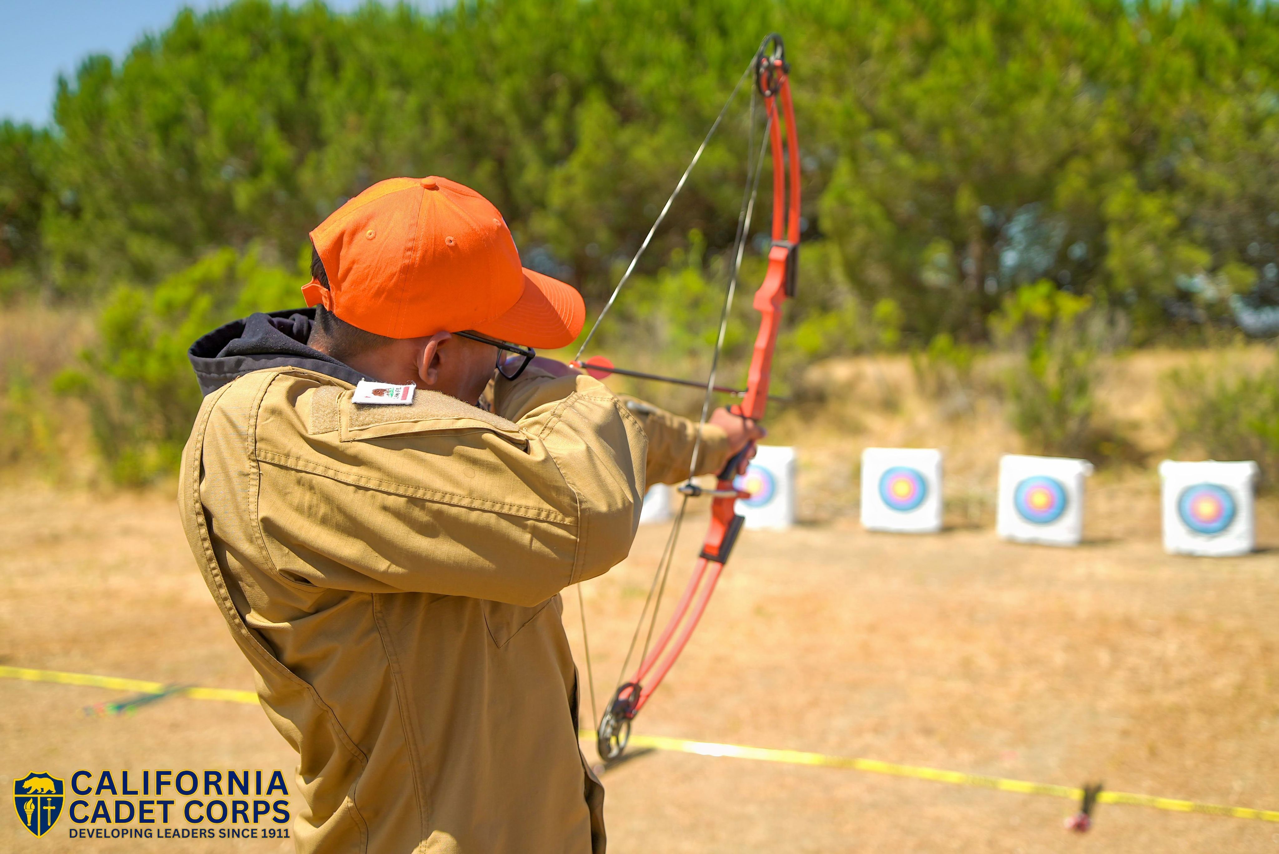 Cadet with bow and arrow practices archery.